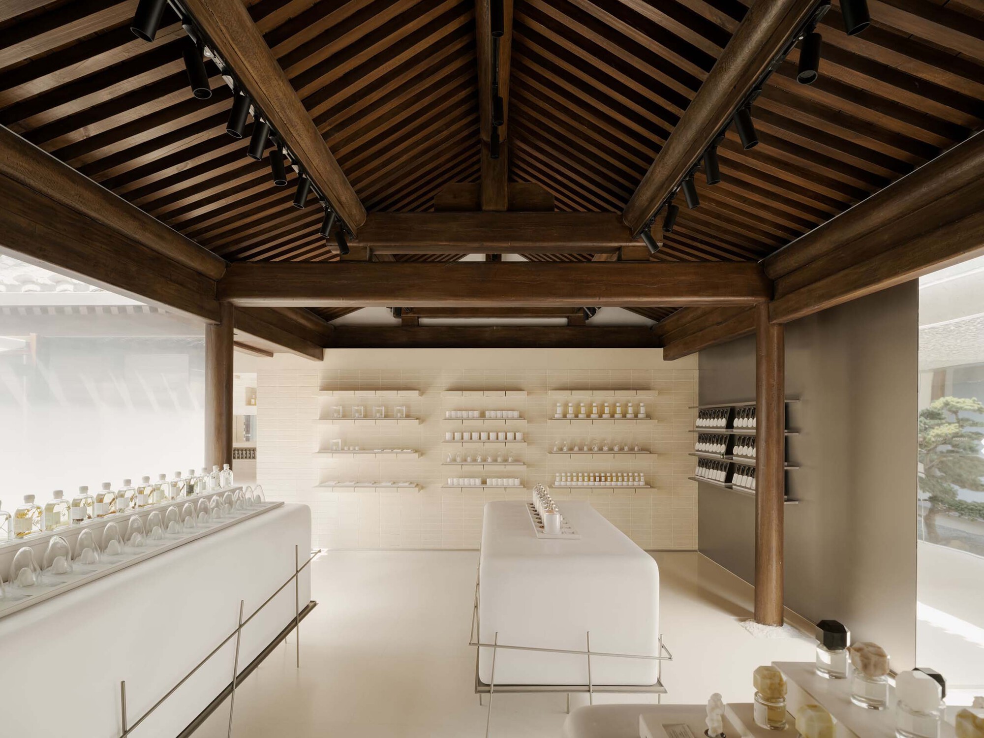 Interior retail space with exposed timber roof beams and white display shelving beneath slatted ceiling