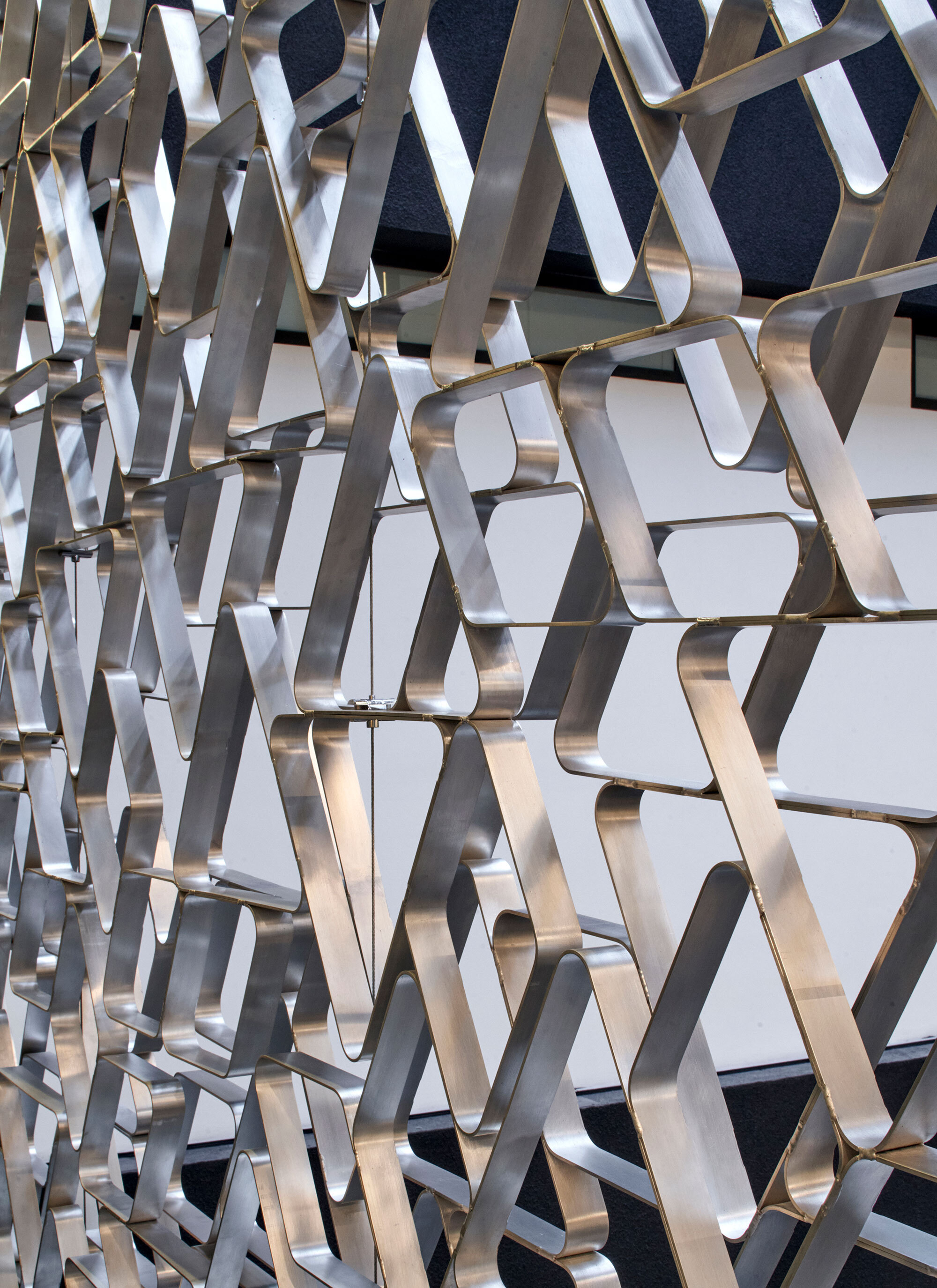 Close-up of the polished metal triangular screen surface catching daylight and shadow