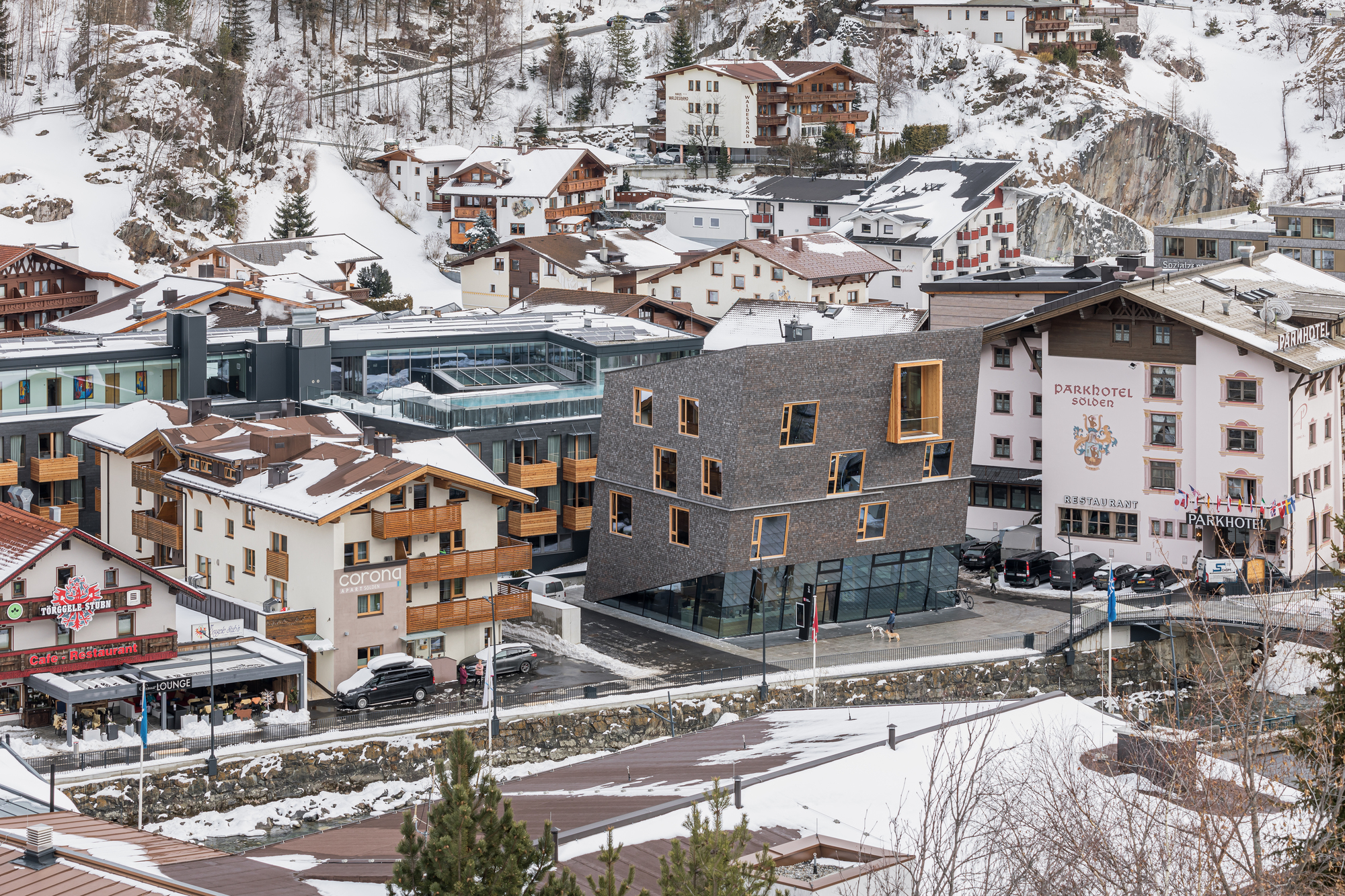 Elevated view of the shingled building set within a snow-covered alpine village
