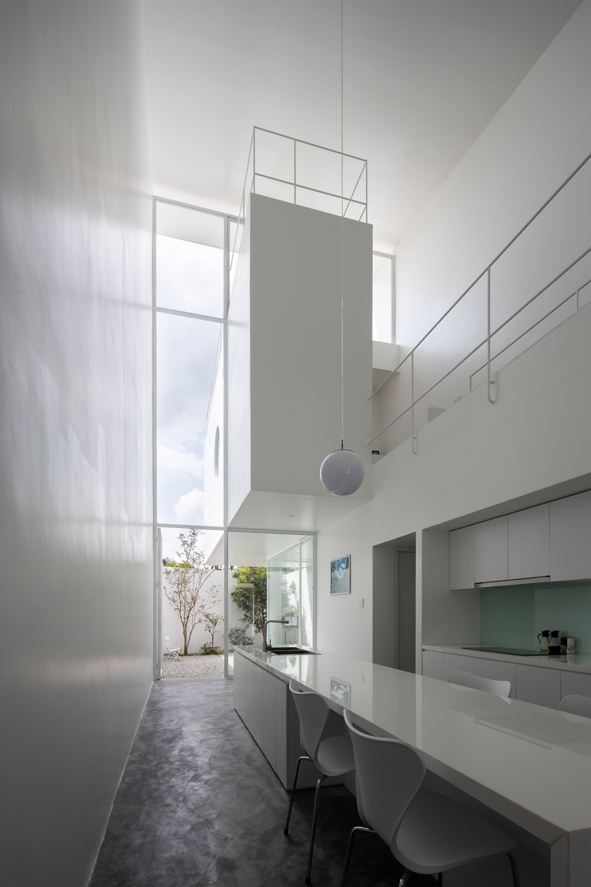 Dining area with high ceiling and tall translucent wall panels casting soft daylight