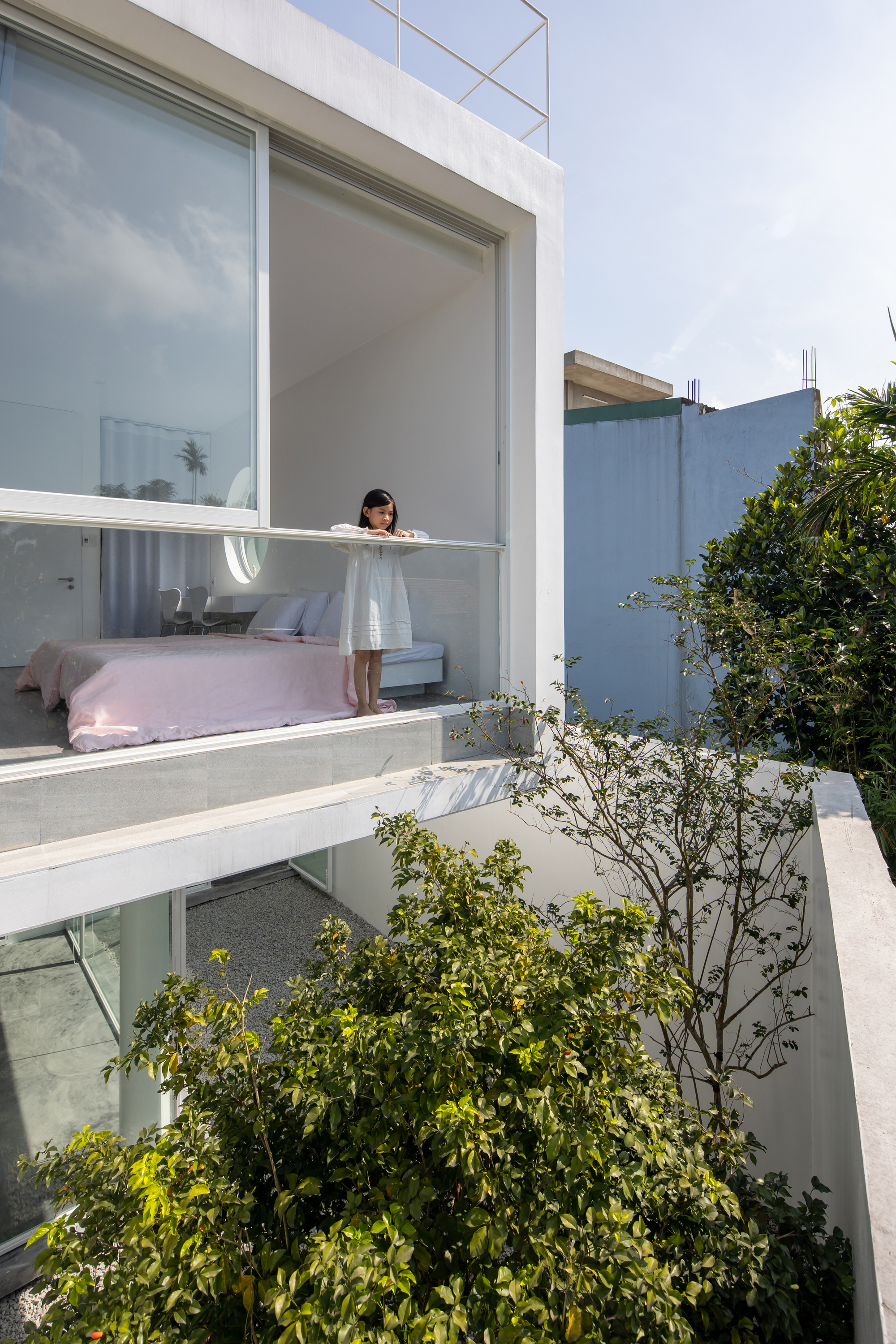 Exterior view of stacked balconies with sliding glass doors and planted terraces below