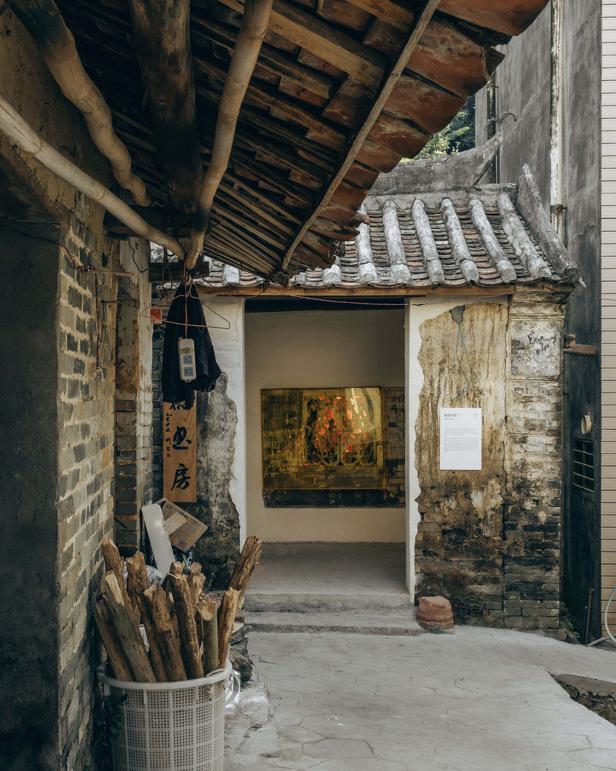 Covered courtyard with exposed timber roof beams and a white gallery entrance under a traditional tile roof