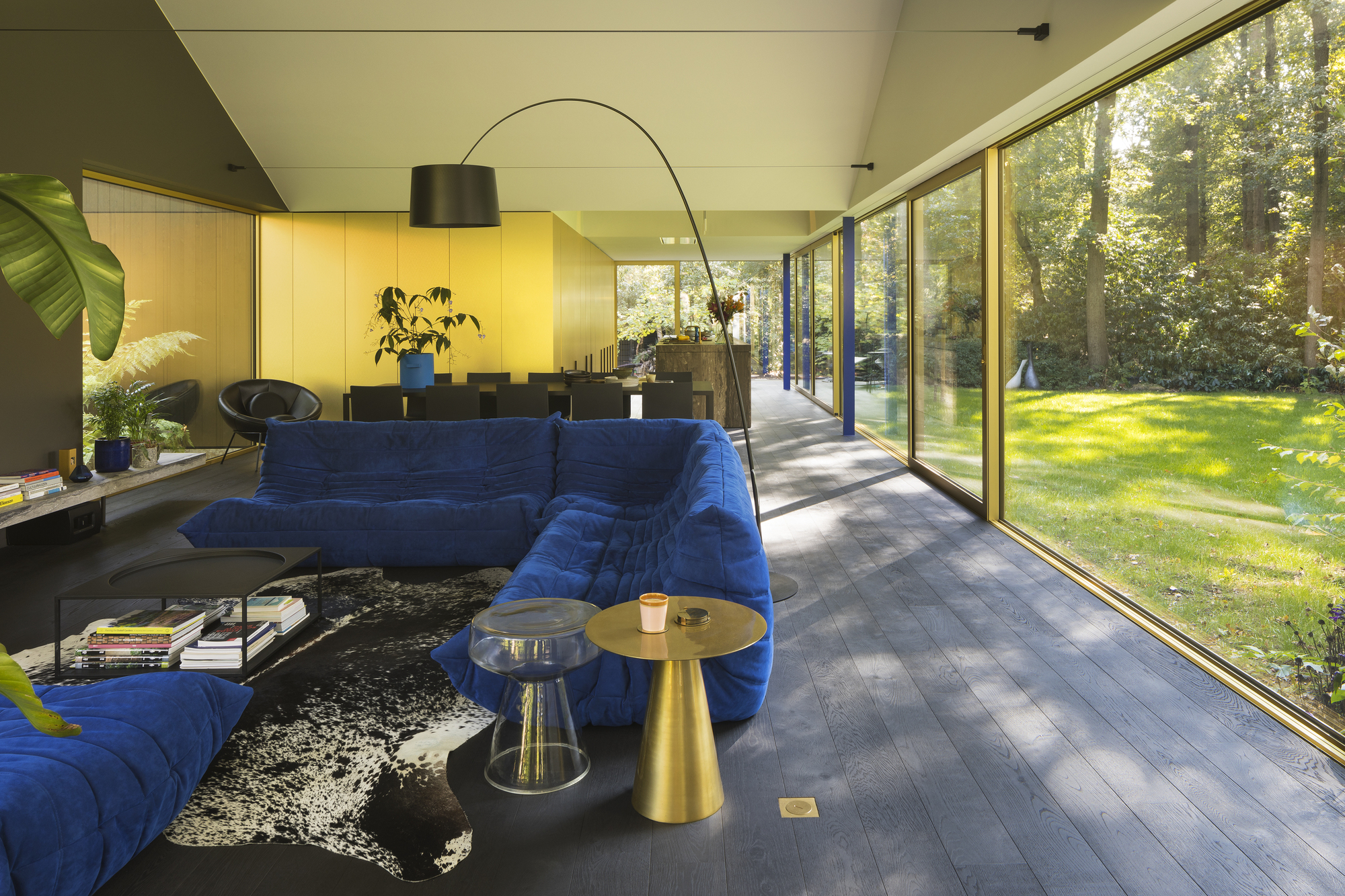 Living room with dark timber floor and sliding glass doors opening to sunlit garden