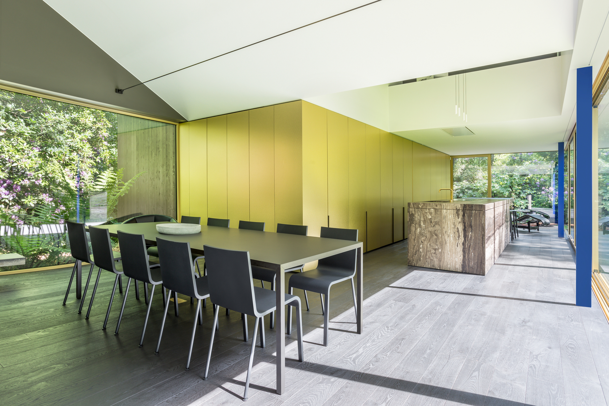 Dining area with brass-clad wall panels and sliding glass doors to an exterior deck