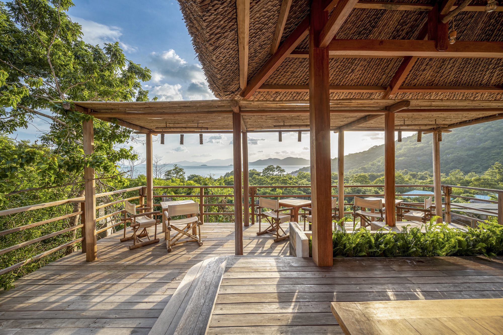 Covered deck with timber columns and cable railing framing mountain vista beyond
