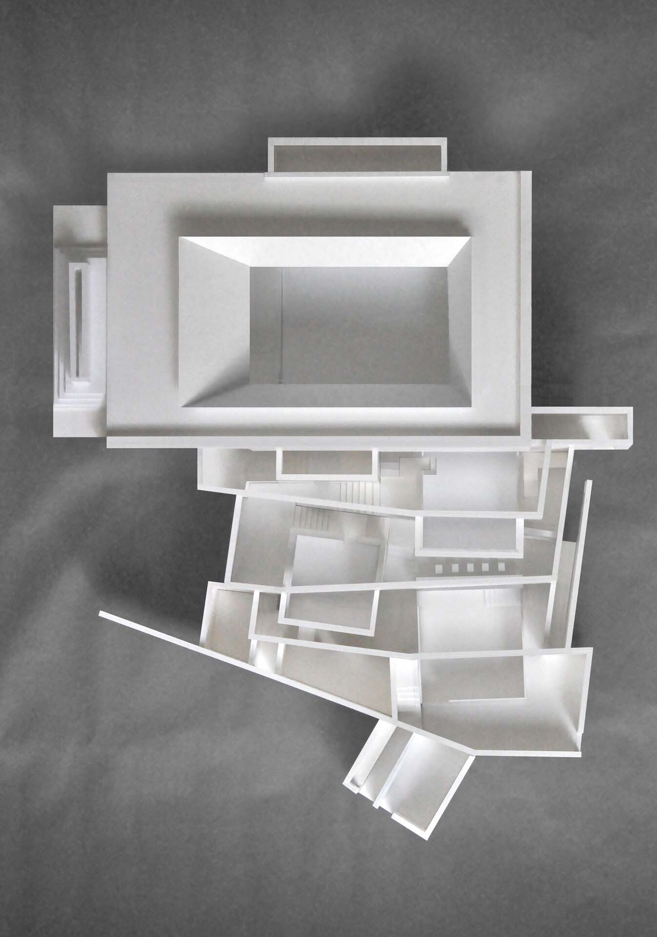 Top-down view of physical sectional model showing central courtyard and radiating angled volumes