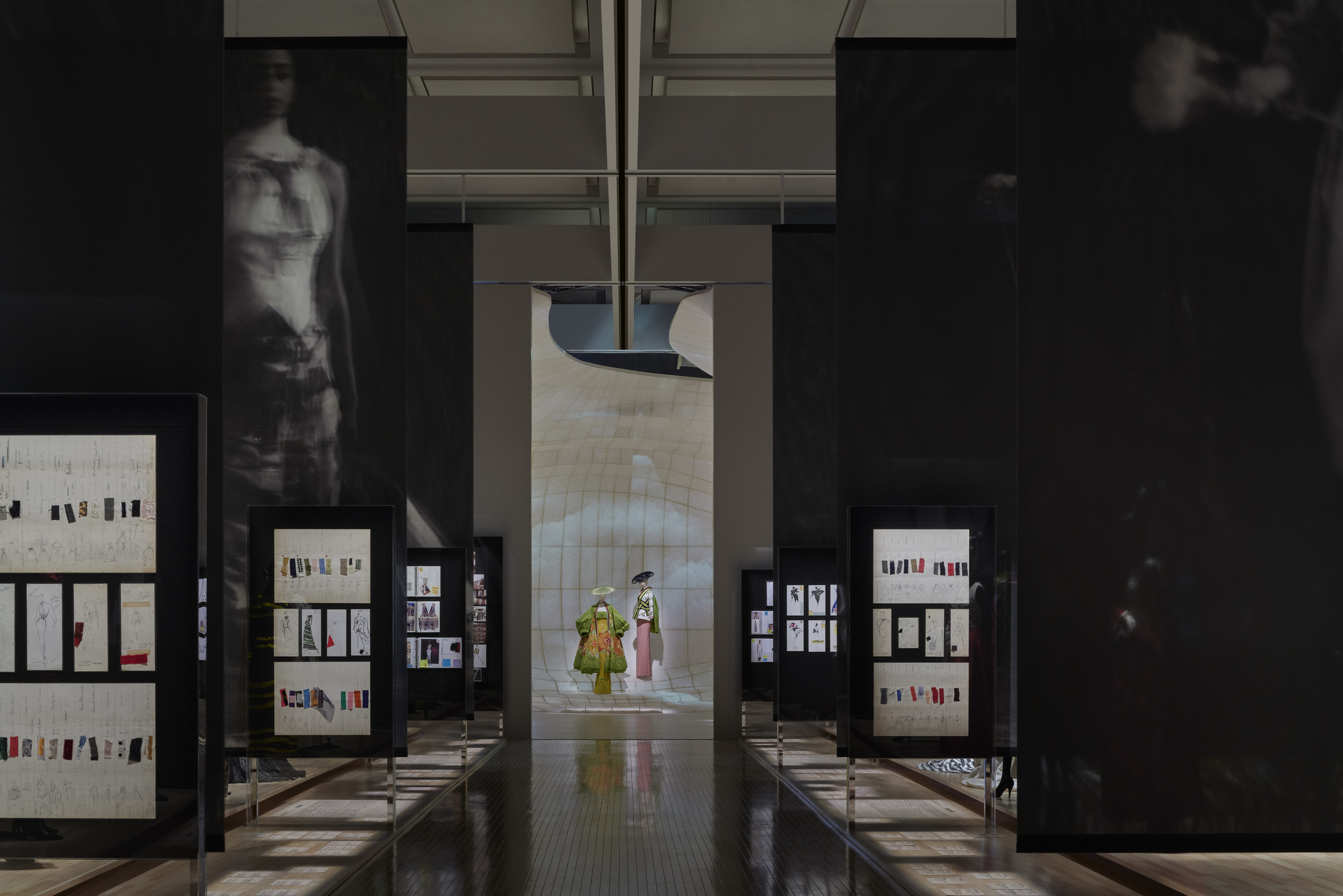 Axial view through exhibition hall with framed display cases flanking a central corridor