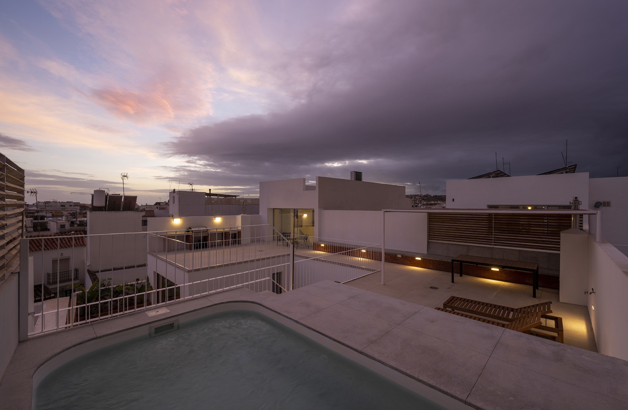 Rooftop terrace with plunge pool and timber screening under a purple twilight sky