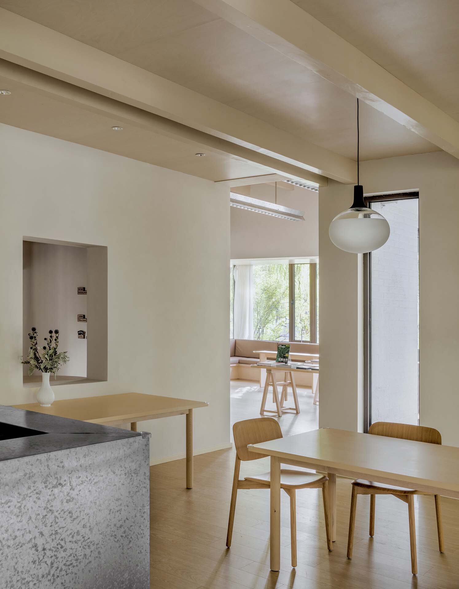 Dining area with terrazzo counter and pendant lamp looking through a doorway to a reading nook