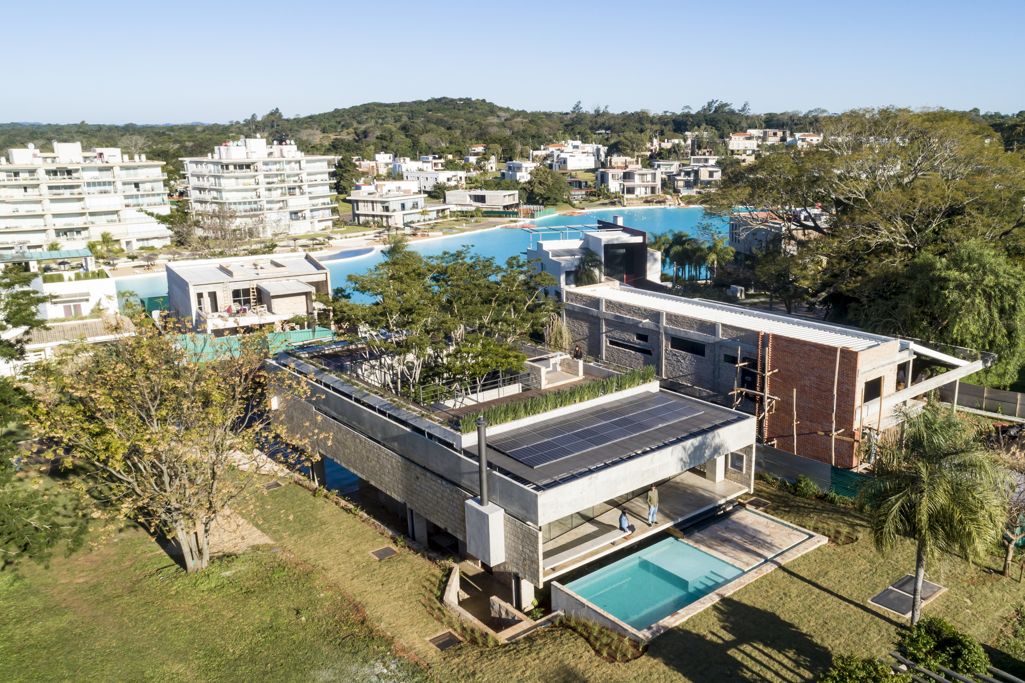 Aerial view of the layered roof planes with solar panels and rooftop garden beds