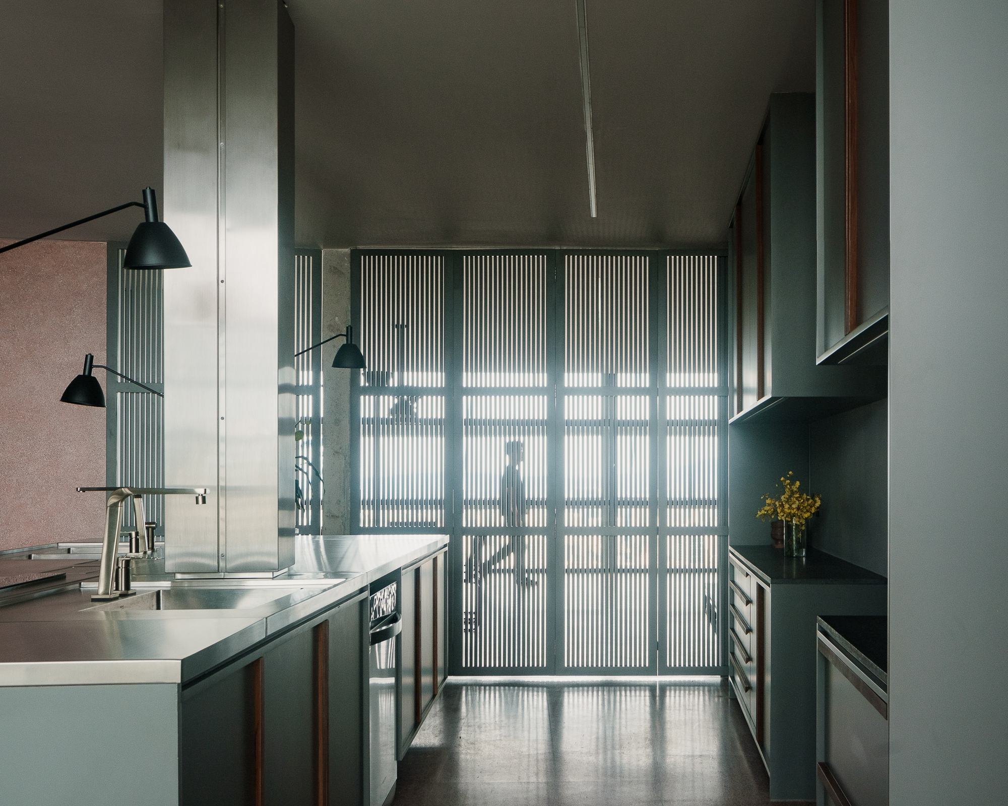 Fluted glass partition casting striped shadows across the polished concrete floor