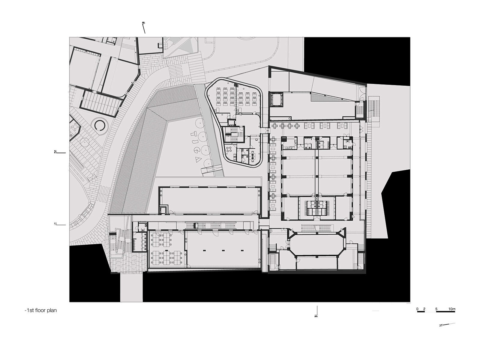 First floor plan showing courtyard, auditorium block, and adjacent structures with landscaped surroundings
