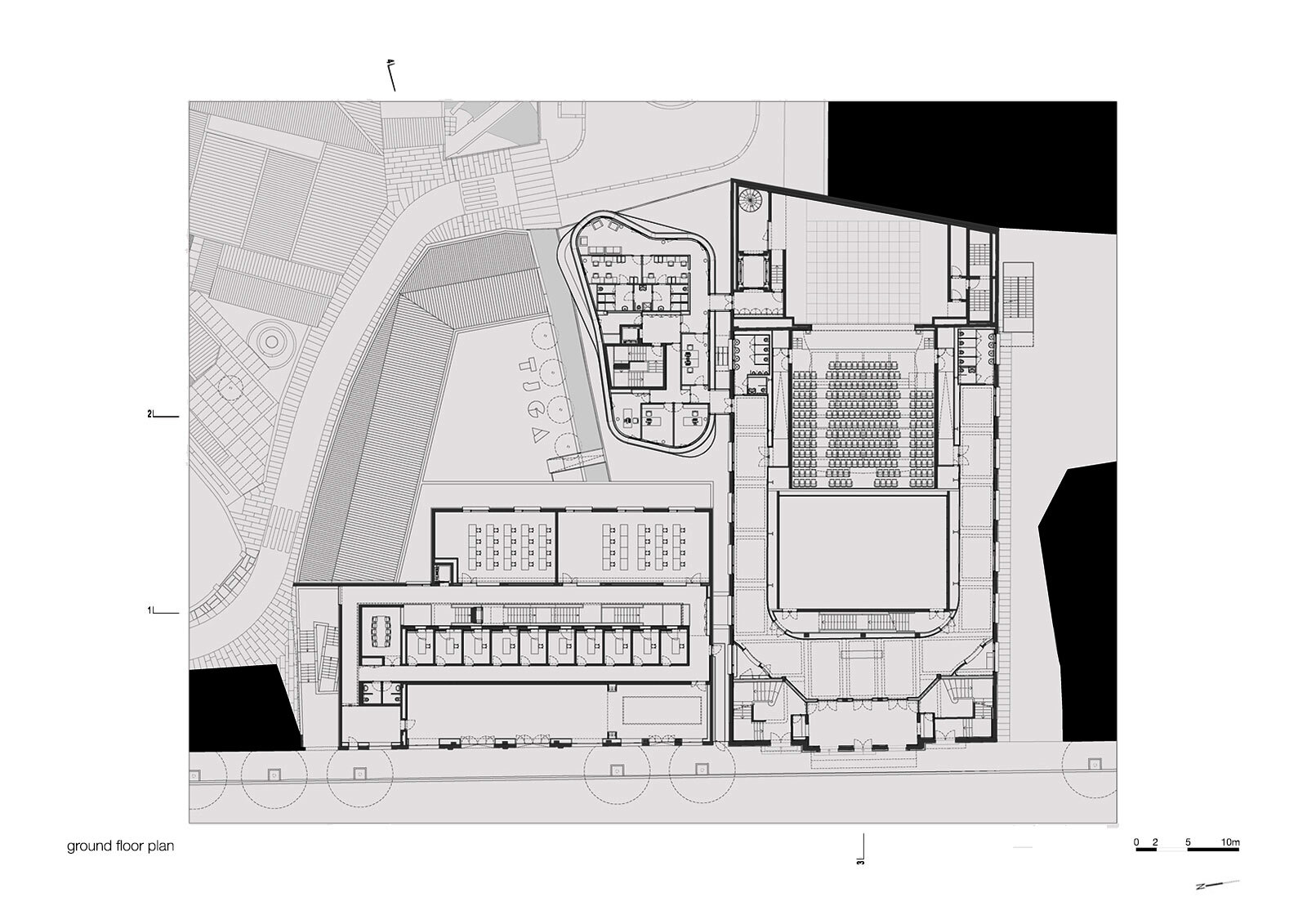 Ground floor plan drawing revealing large performance hall, seating rows, and circulation zones with adjacent courtyard