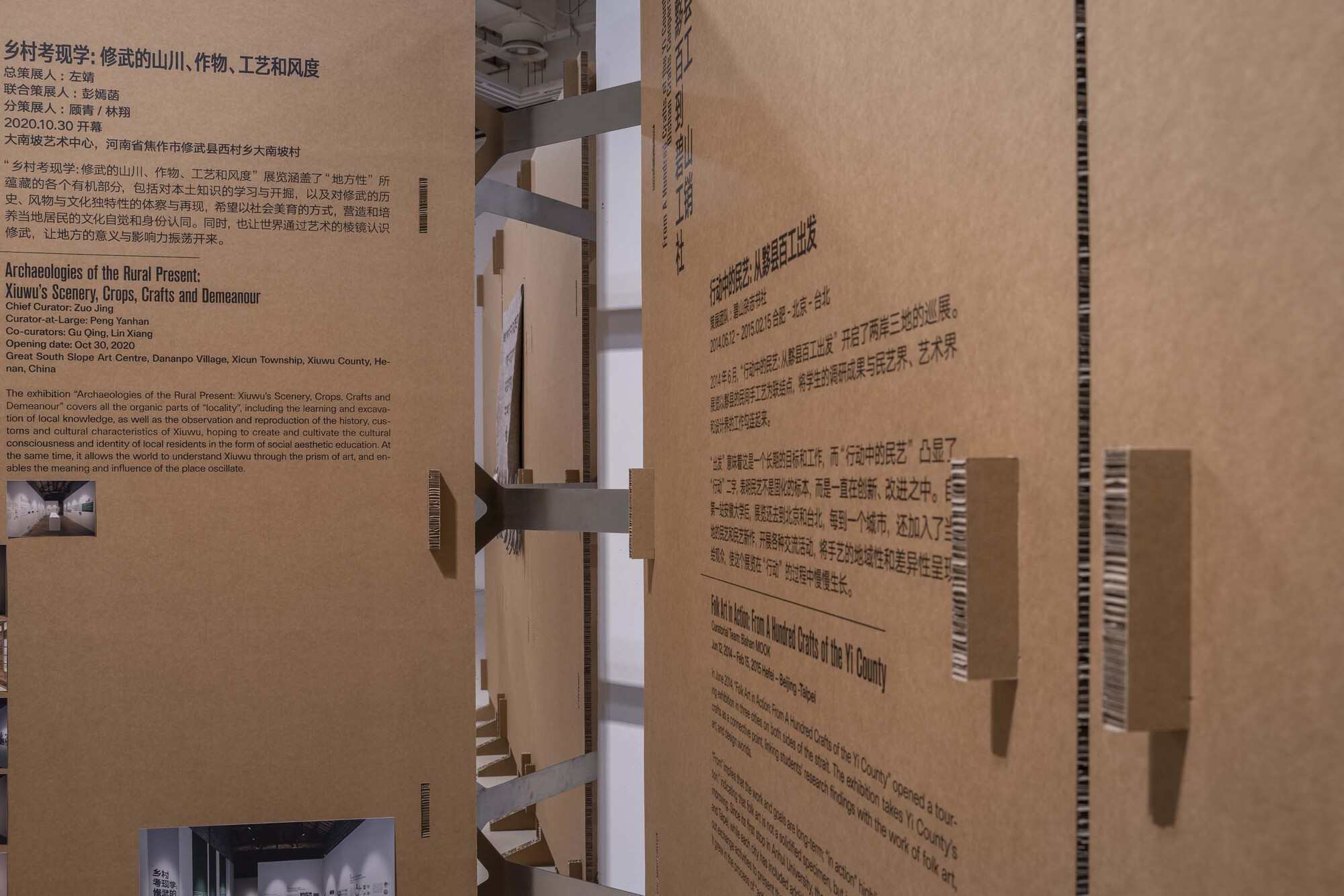 Cardboard architectural model with text panels and interior openings revealing layered spaces
