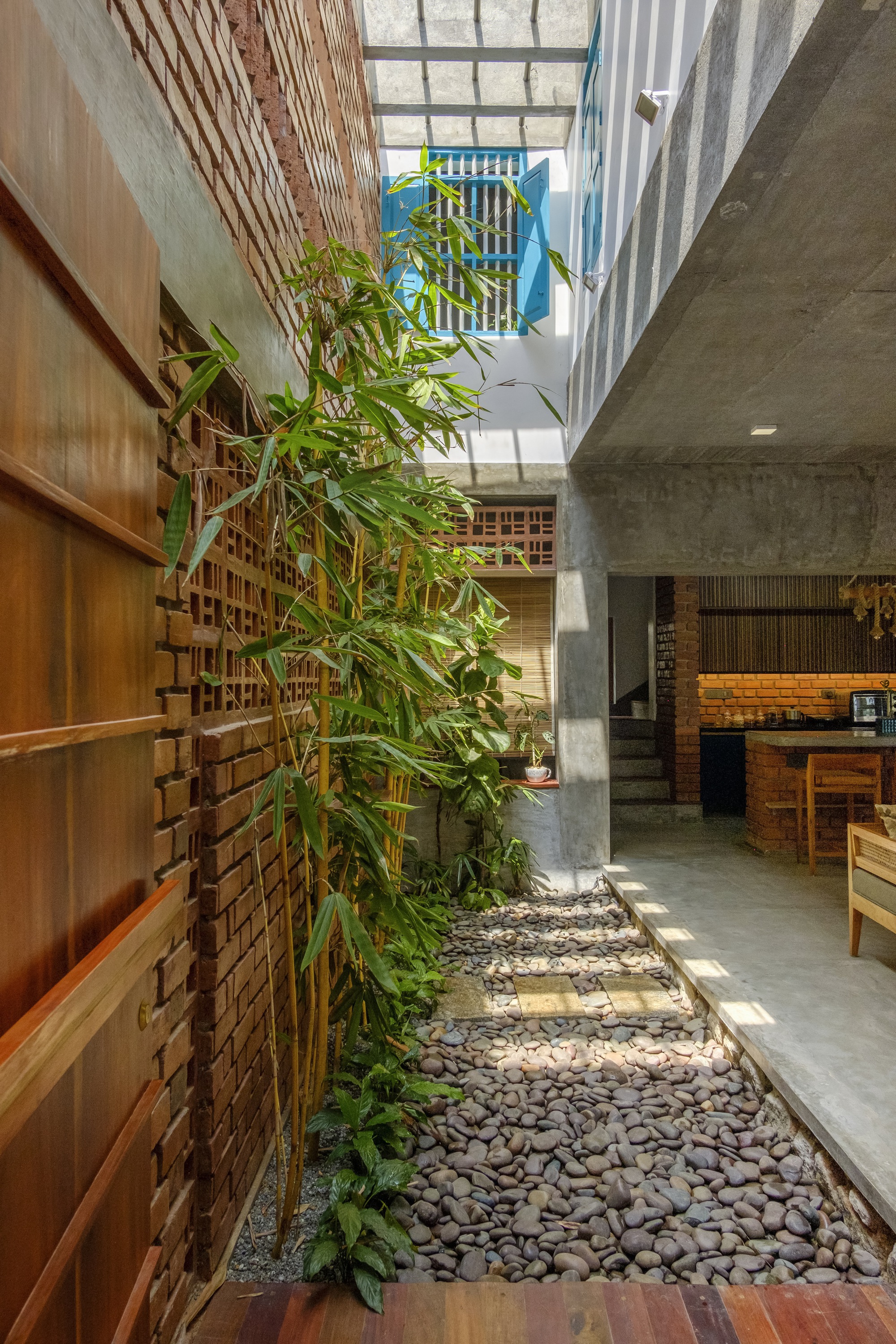 Interior courtyard with bamboo planting, pebble ground, and glazed skylight above