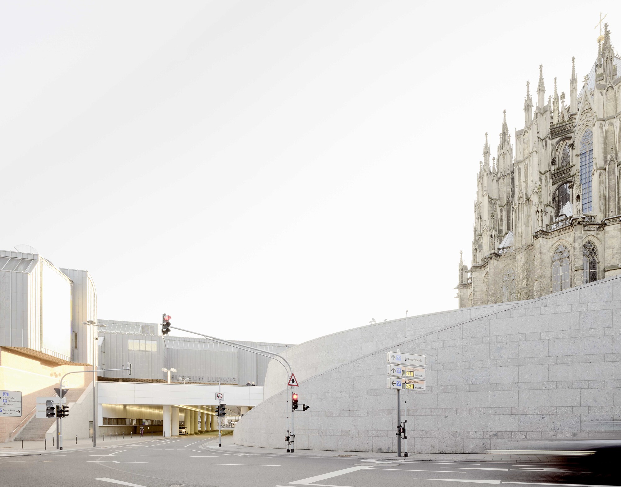 Stone block retaining wall meeting an intersection beneath the spires of a gothic cathedral