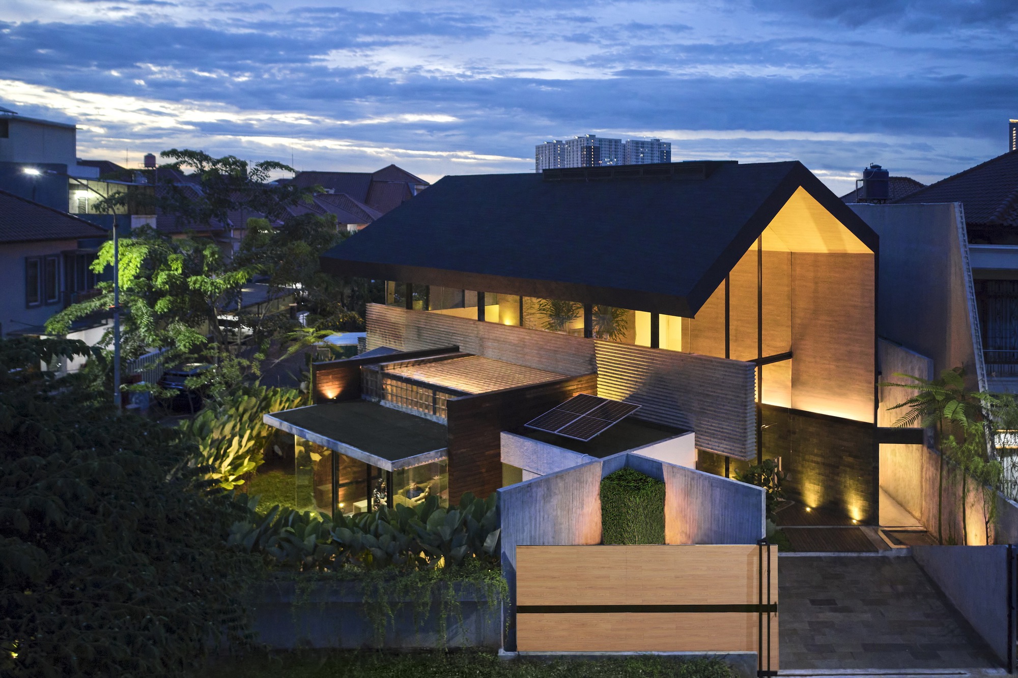 Aerial view of the split-pitched roof with solar panels and illuminated courtyard at dusk