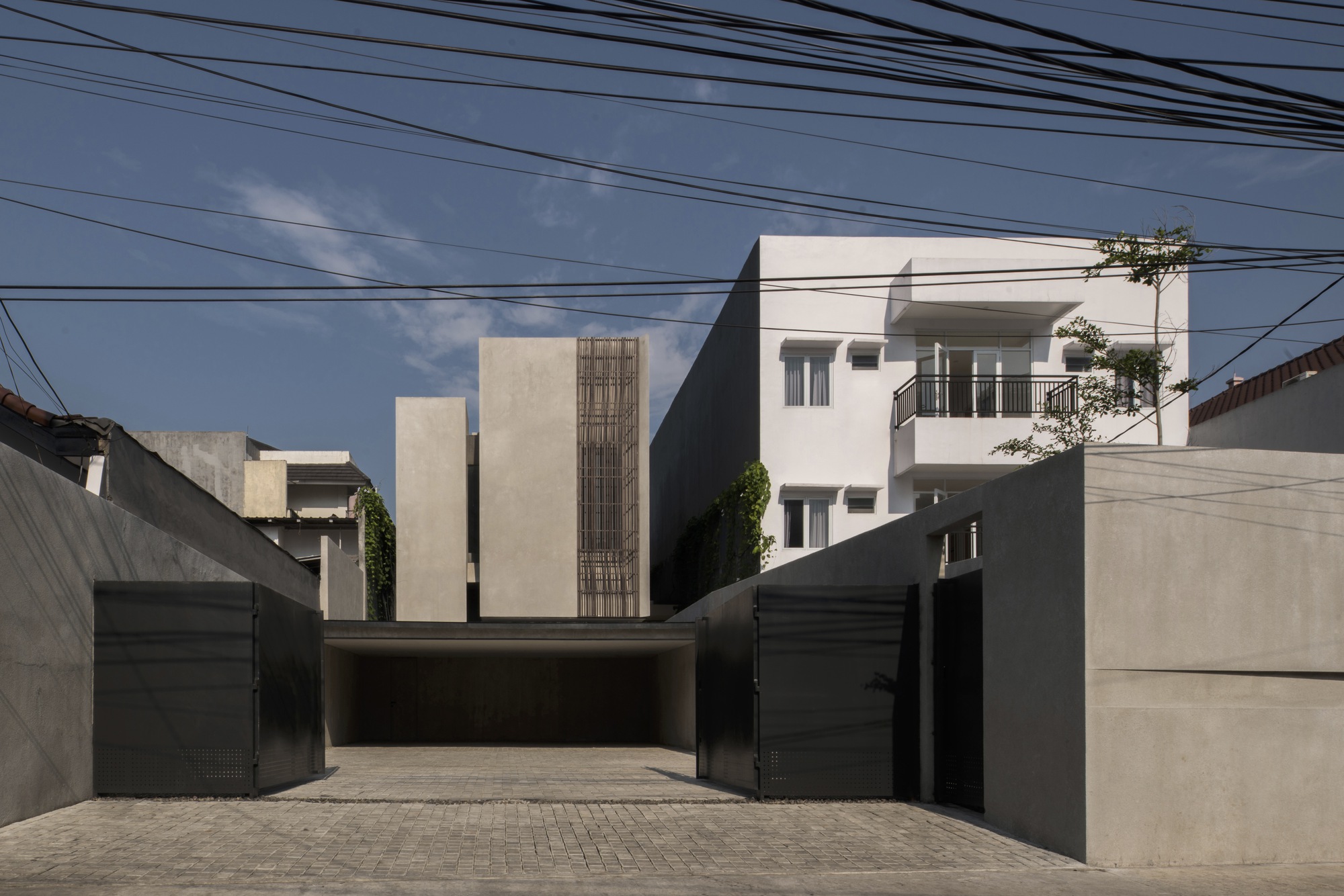 Street view of the concrete facade with vertical timber screening and overhead power lines