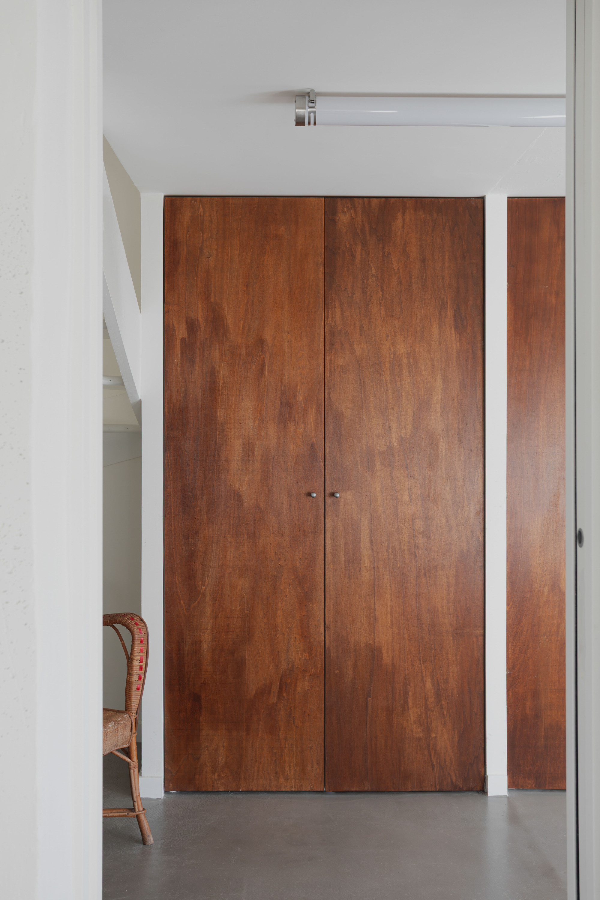 Timber double doors with white frame and sidelight panel opening to a polished concrete floor