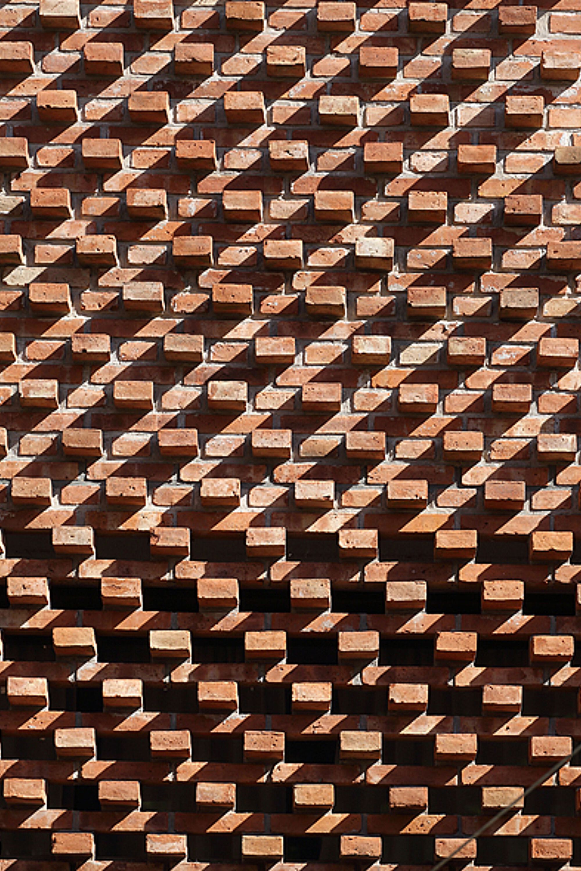 Detail of the projecting brick coursing in afternoon sunlight creating geometric relief