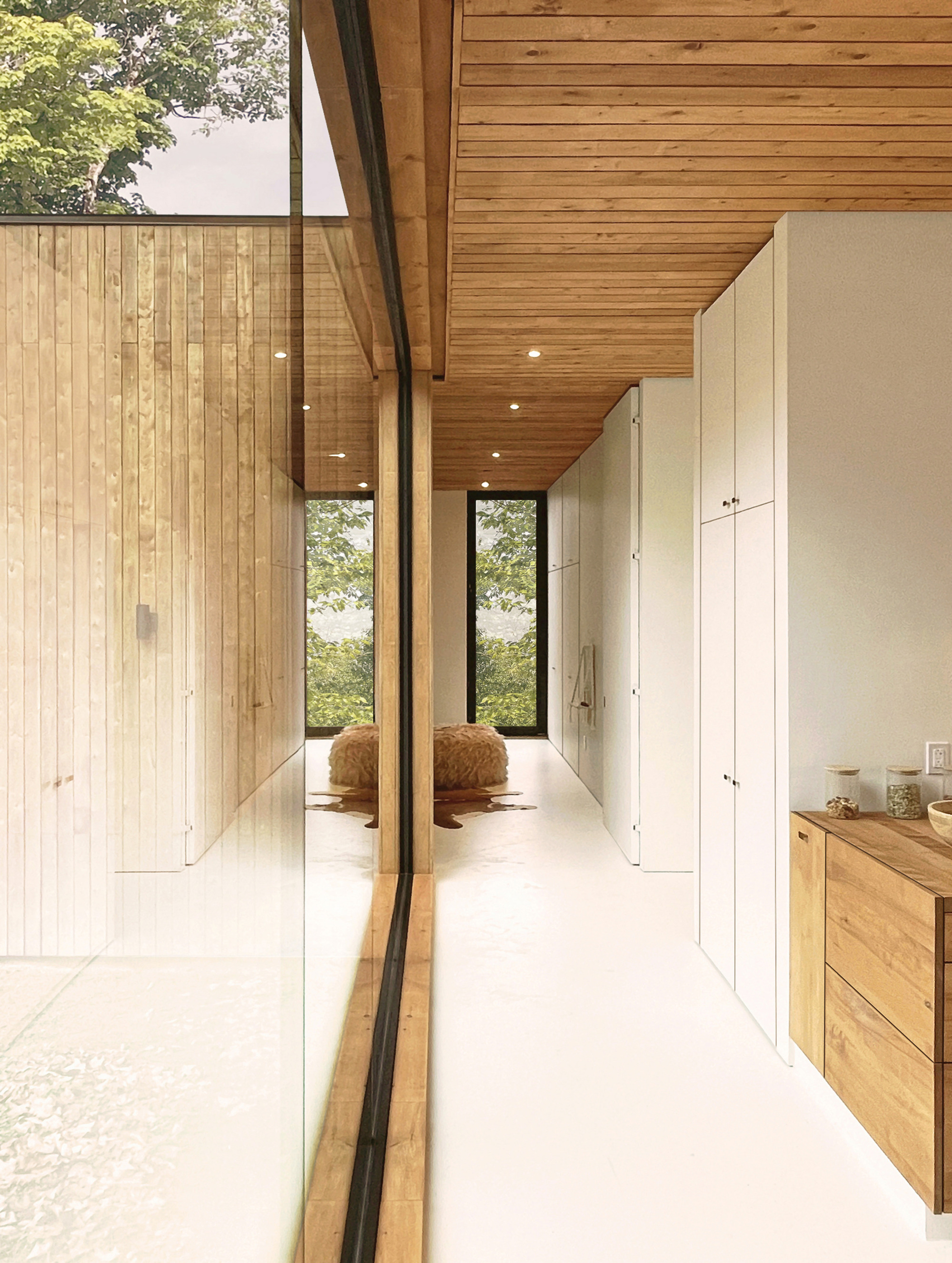 Corridor with timber plank walls and polished white floor reflecting daylight from windows ahead