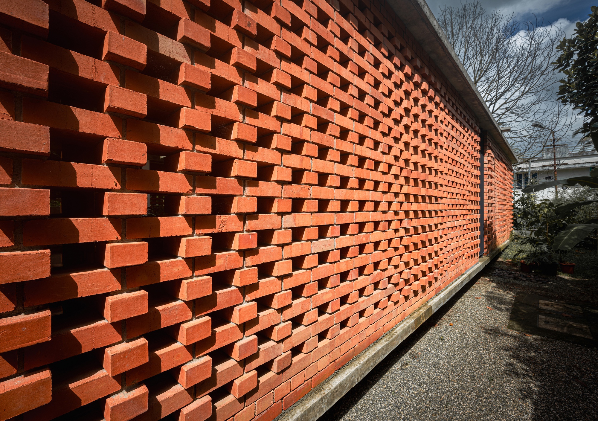 Close-up of the staggered brick screen wall with protruding units creating deep shadows