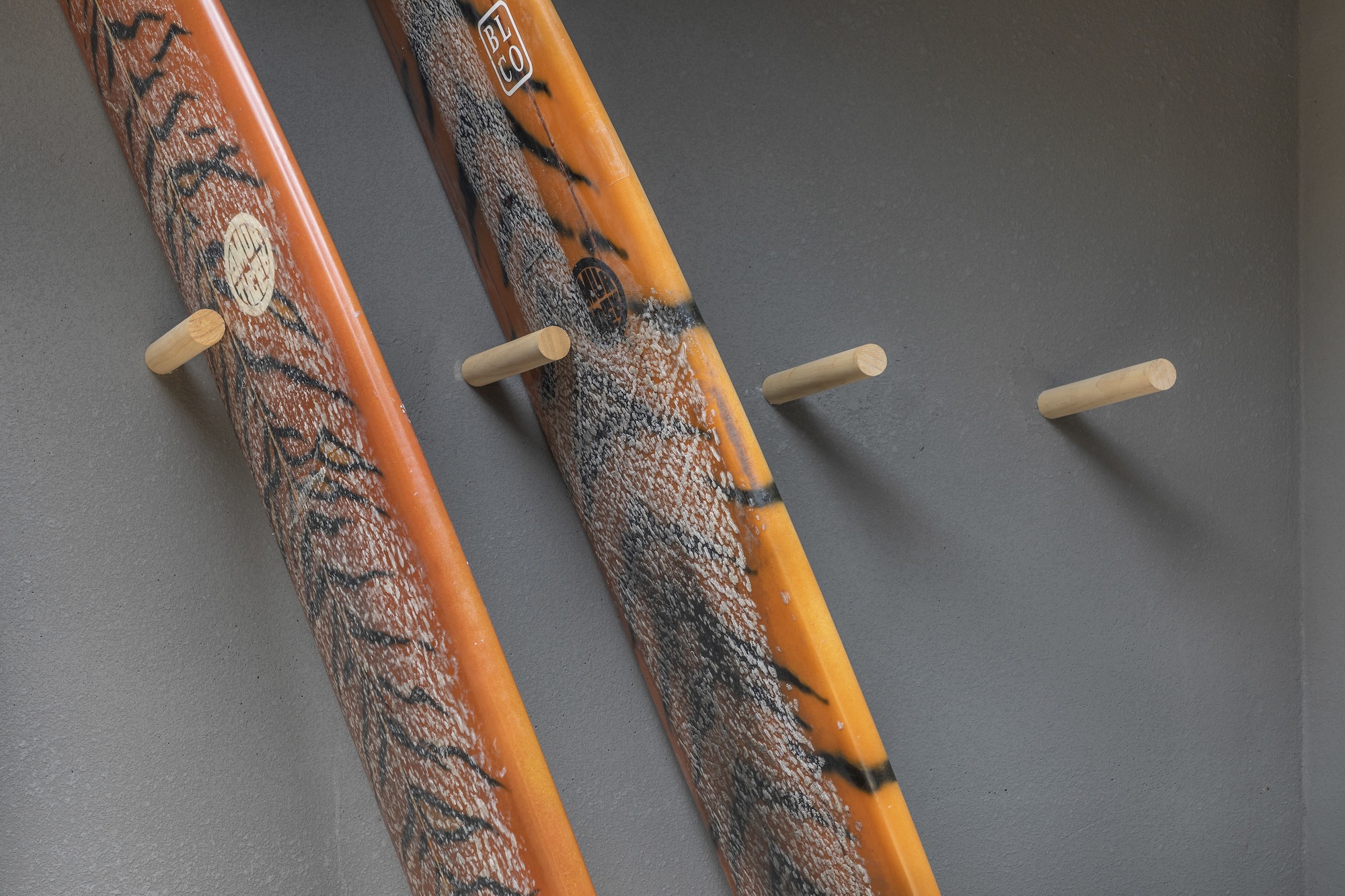 Timber handrails wrapped in textured rope alongside wooden pegs mounted on a grey wall
