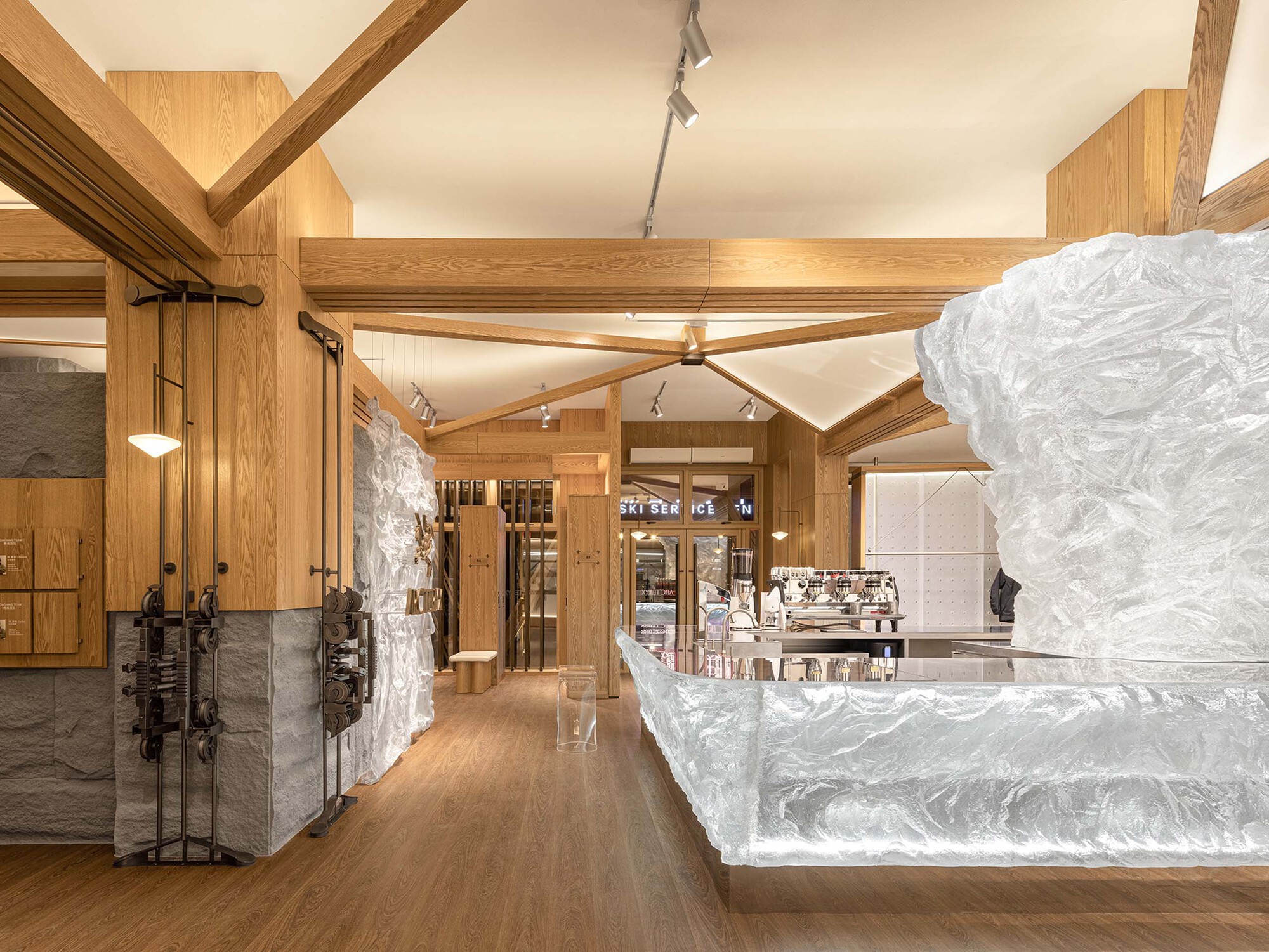 Interior view of timber framing and white sculpted counter with glass doors and display shelving beyond