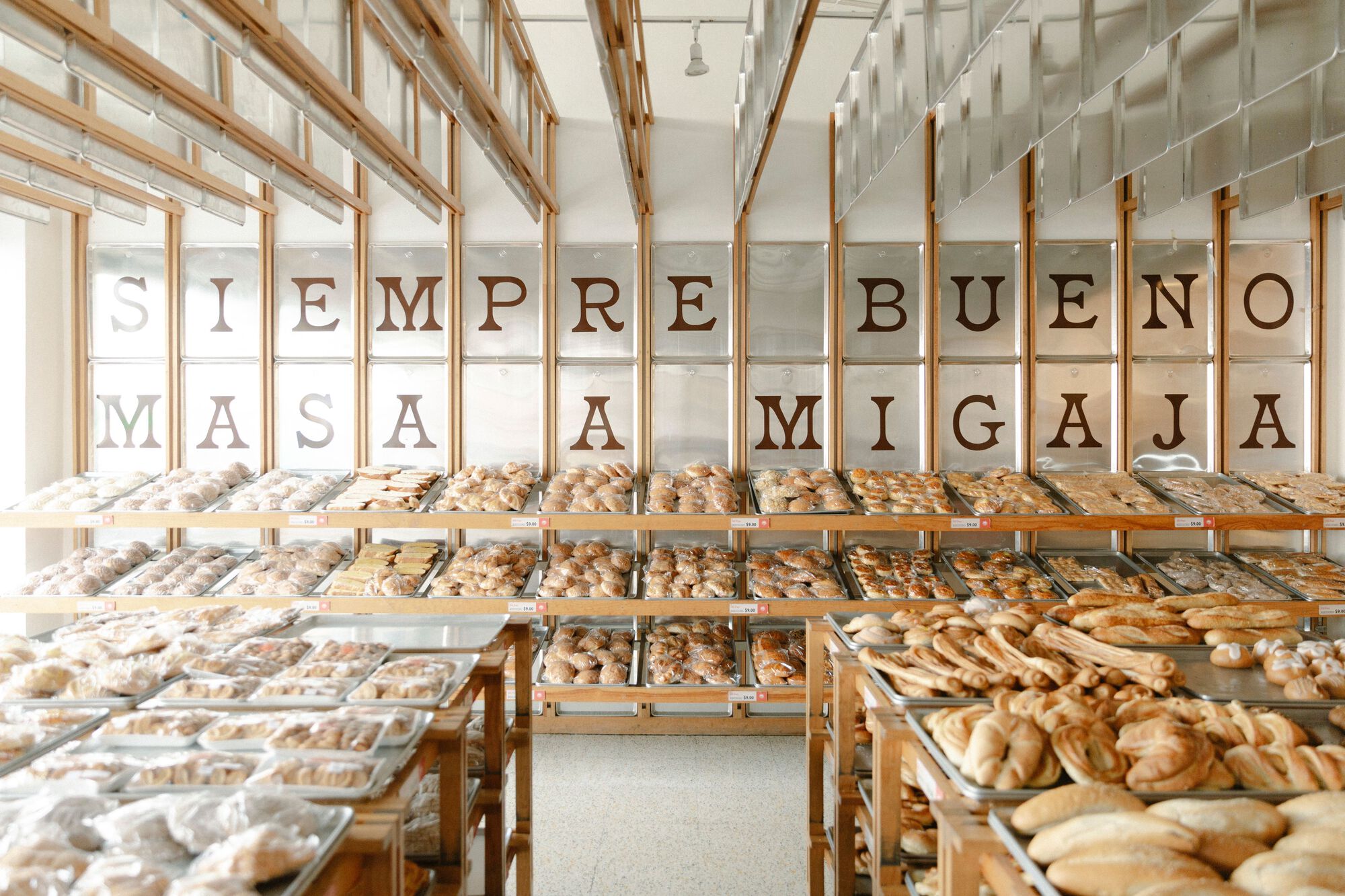 Wide view of the timber shelving system with hanging glass panels and trays of baked goods