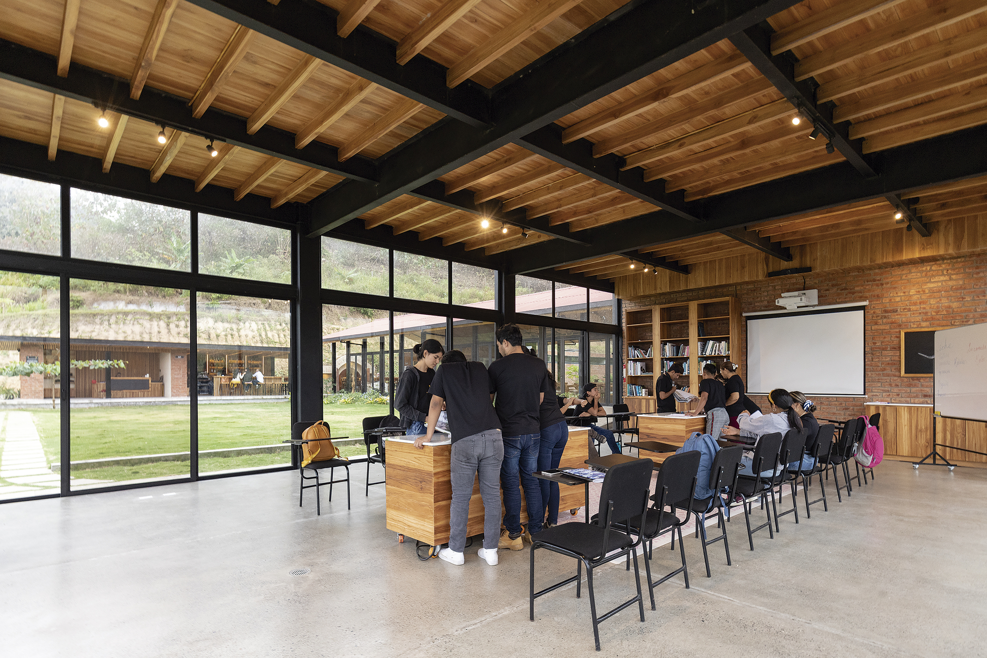 Interior event space with exposed timber joists and steel beams above polished concrete flooring