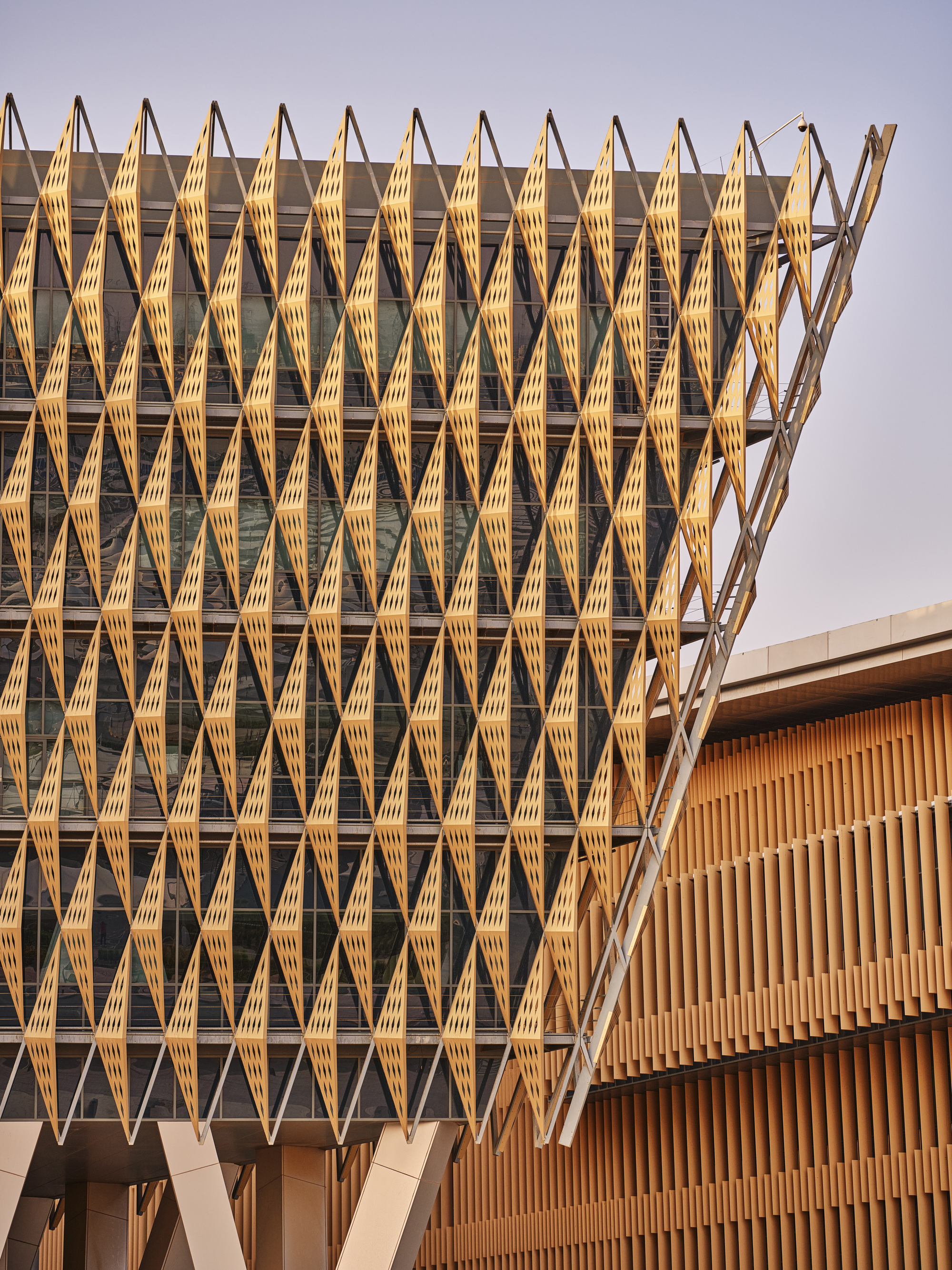 Close-up of the repeating timber brise-soleil with diamond module pattern in golden hour sun