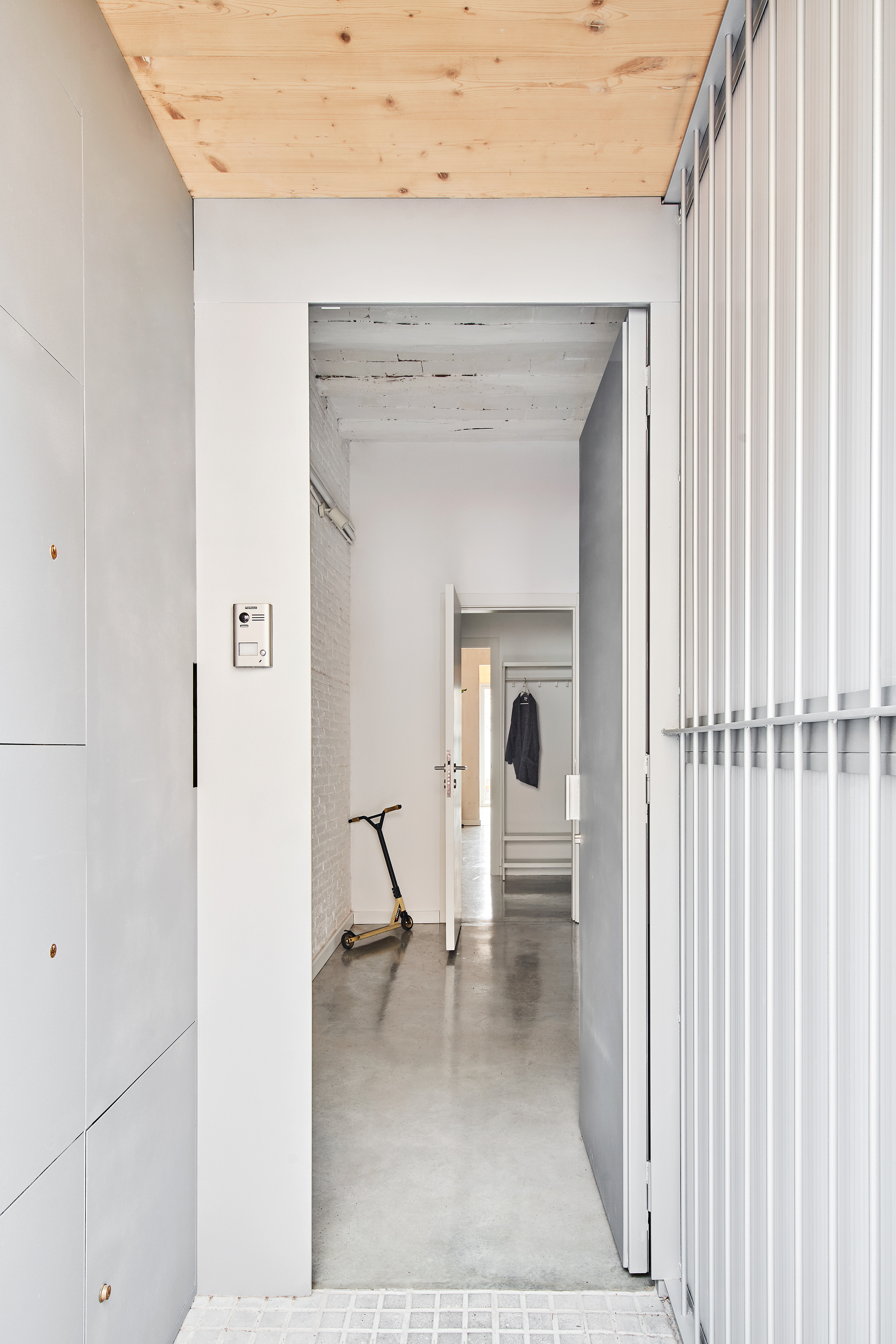 Corridor view through aligned doorways with scooter parked midway along polished concrete floor