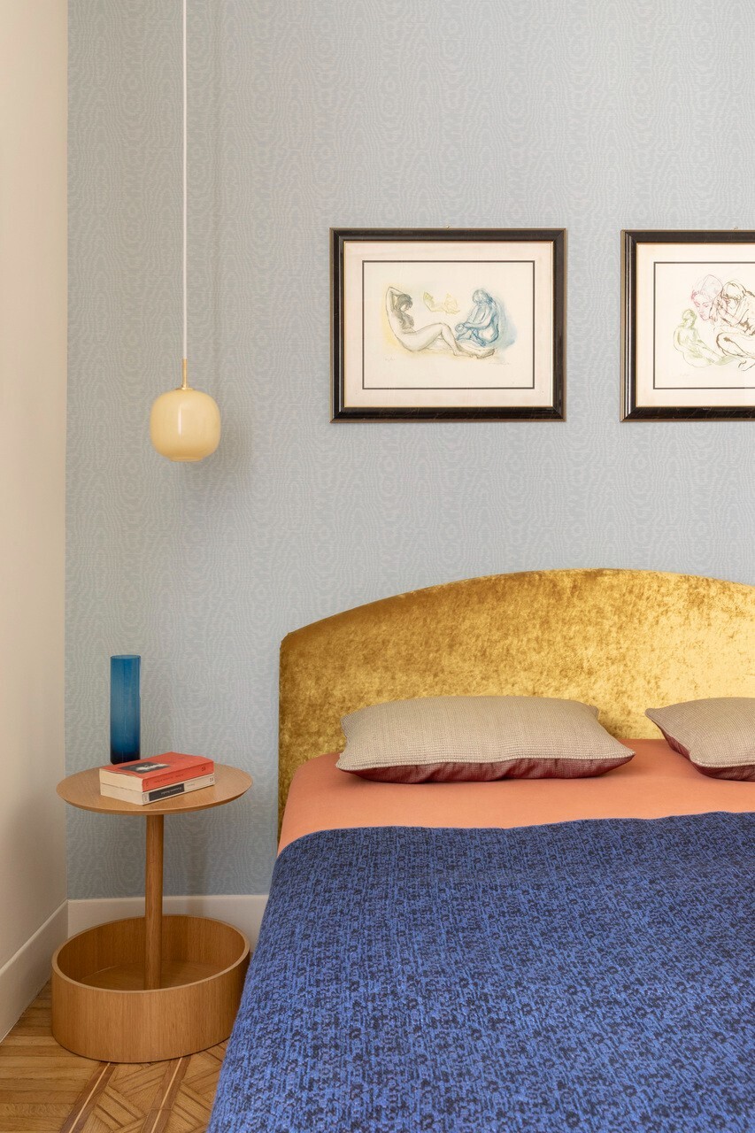 Bedroom with gold velvet headboard and pendant light above a timber bedside table