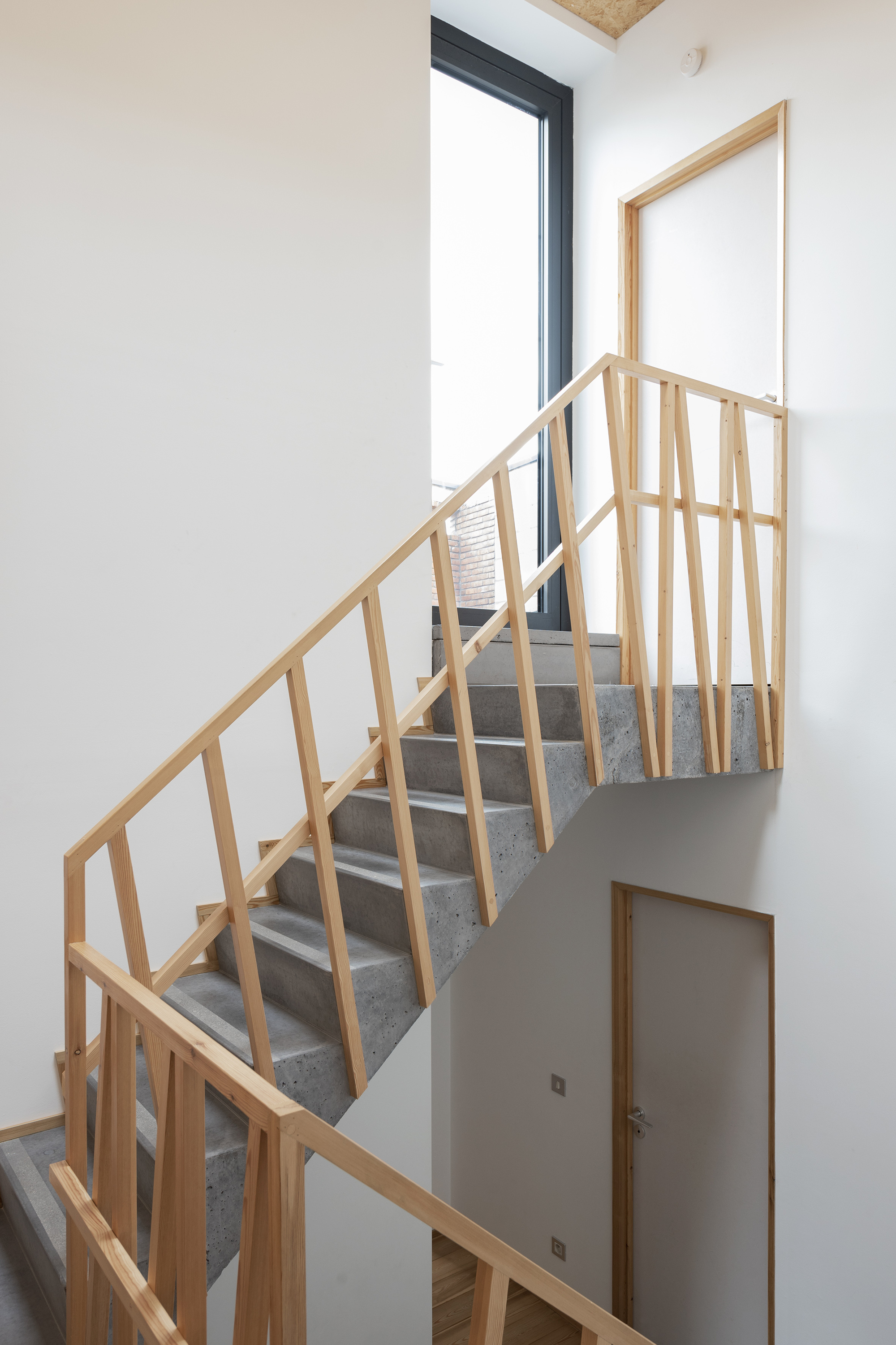 Steel and timber staircase with vertical wood balustrade leading to upper level skylight