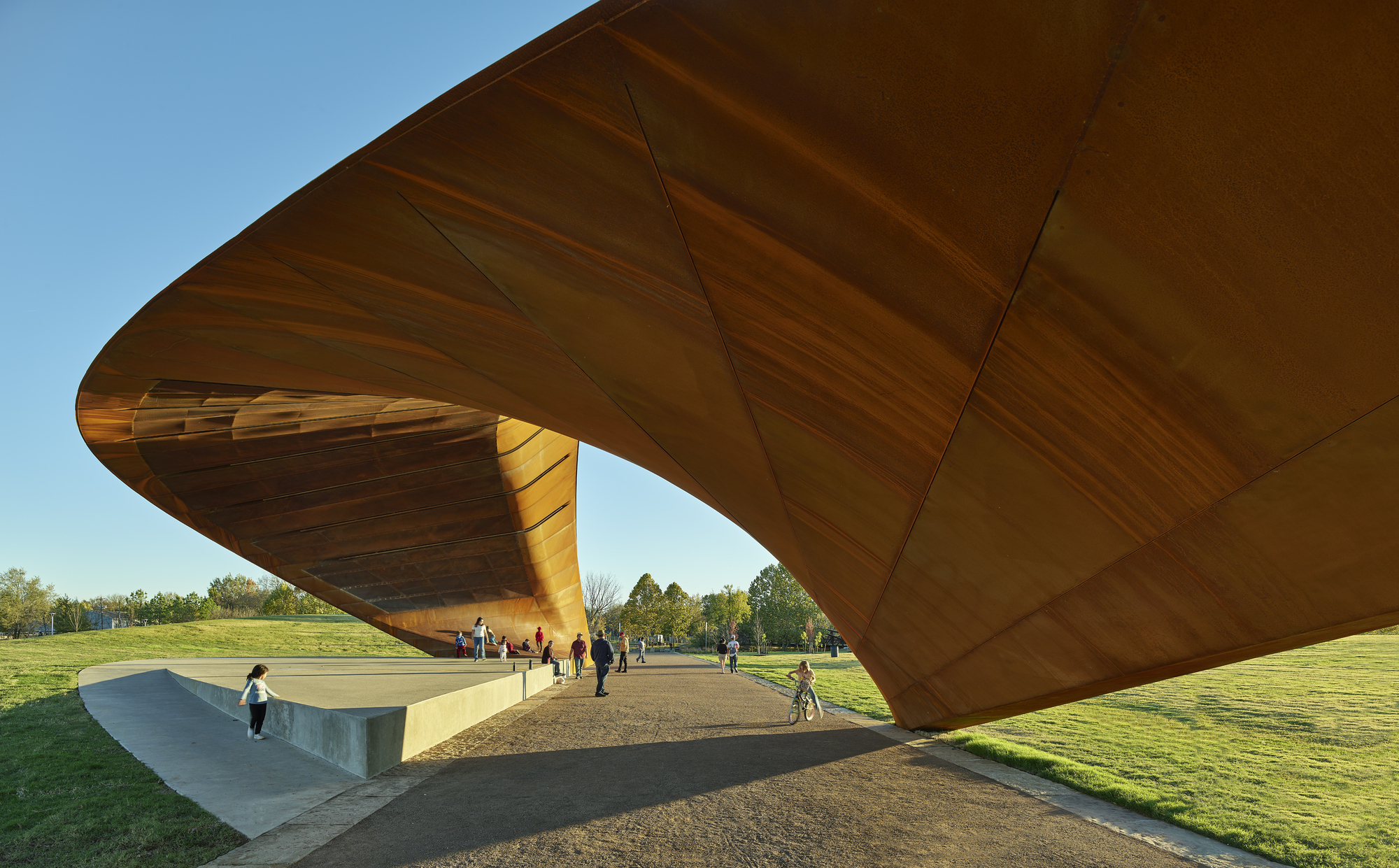 Underside of the laminated timber roof showing structural panels and column with visitors below