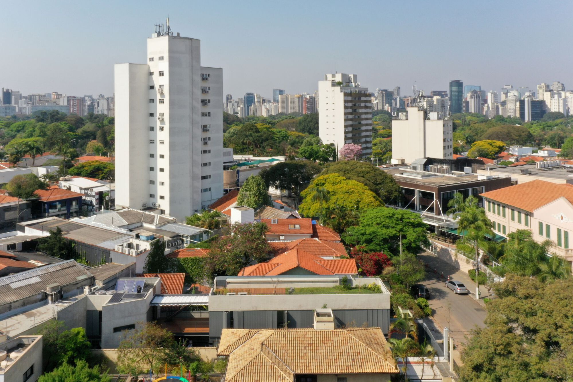 Elevated view of the residence with flat roof terrace amid dense urban neighborhood