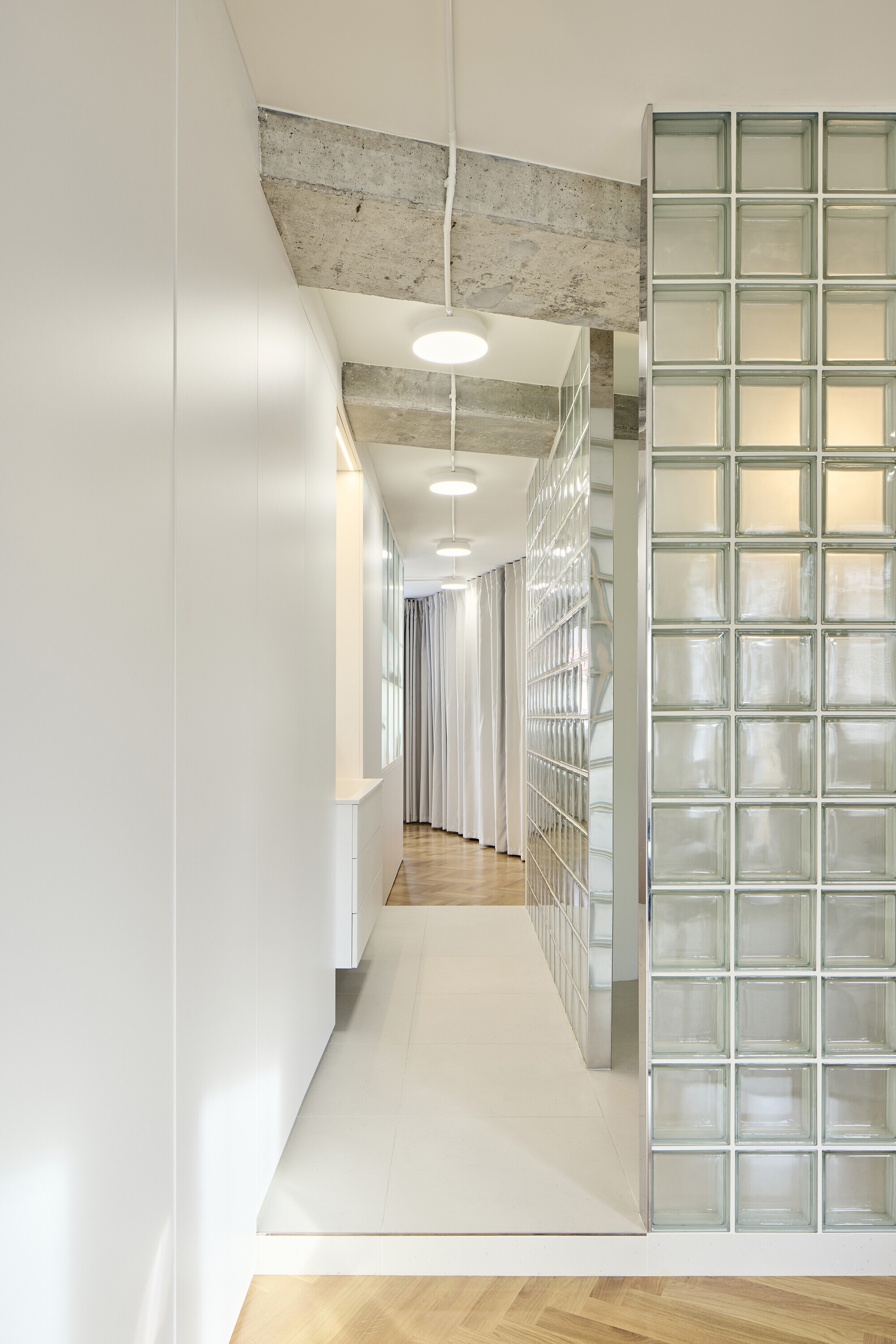 Corridor detail with glass block wall and view through to herringbone parquet flooring
