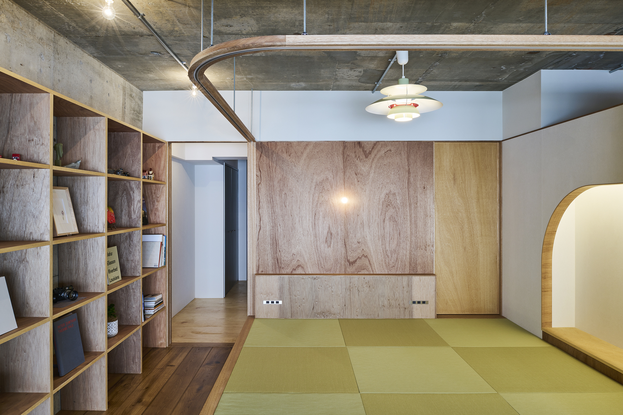Raised tatami mat platform with curved timber curtain rail and pendant light overhead