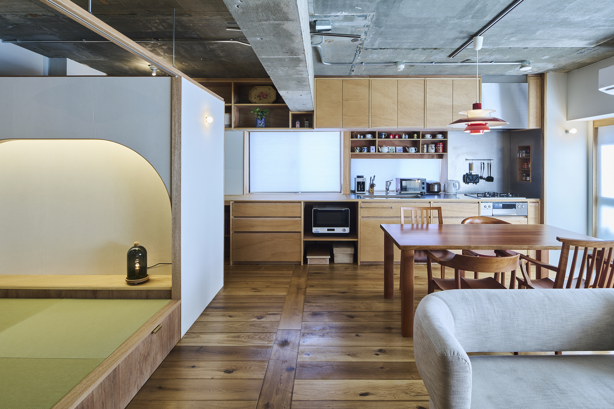 Kitchen and dining area with timber cabinetry and arched opening to tatami platform