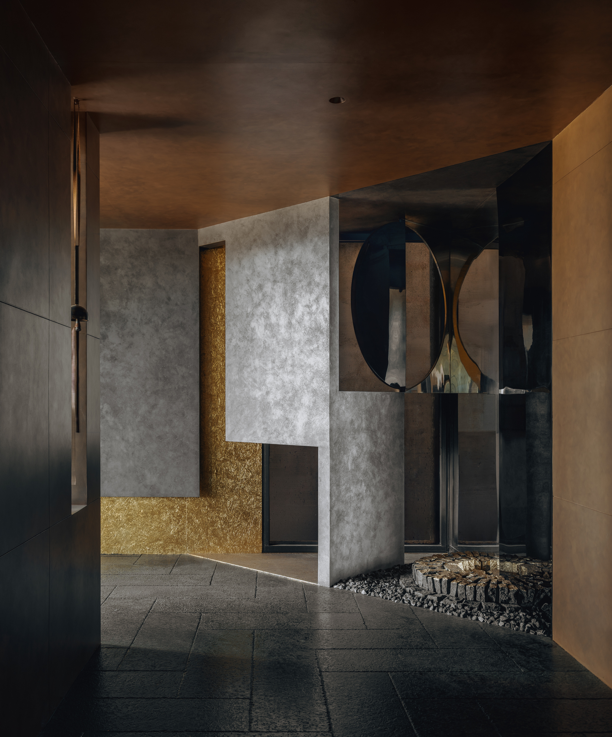 Entry foyer with gold-leaf wall panel behind concrete partition under timber ceiling