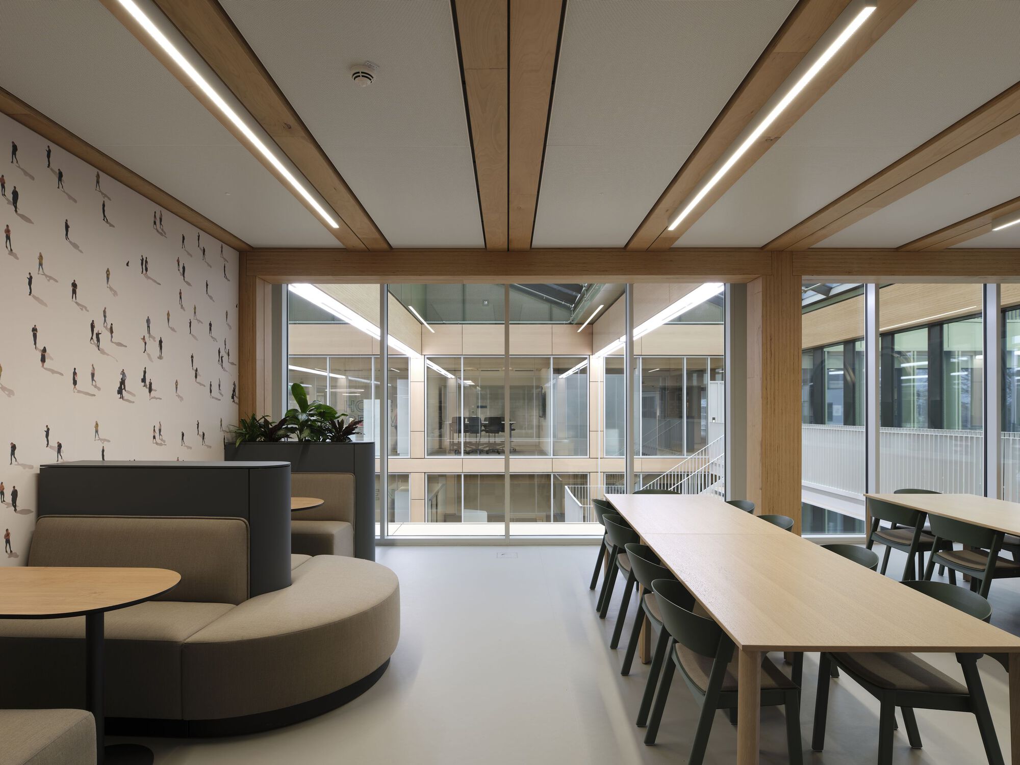 Interior lounge space with circular seating overlooking a glazed atrium with visible levels beyond