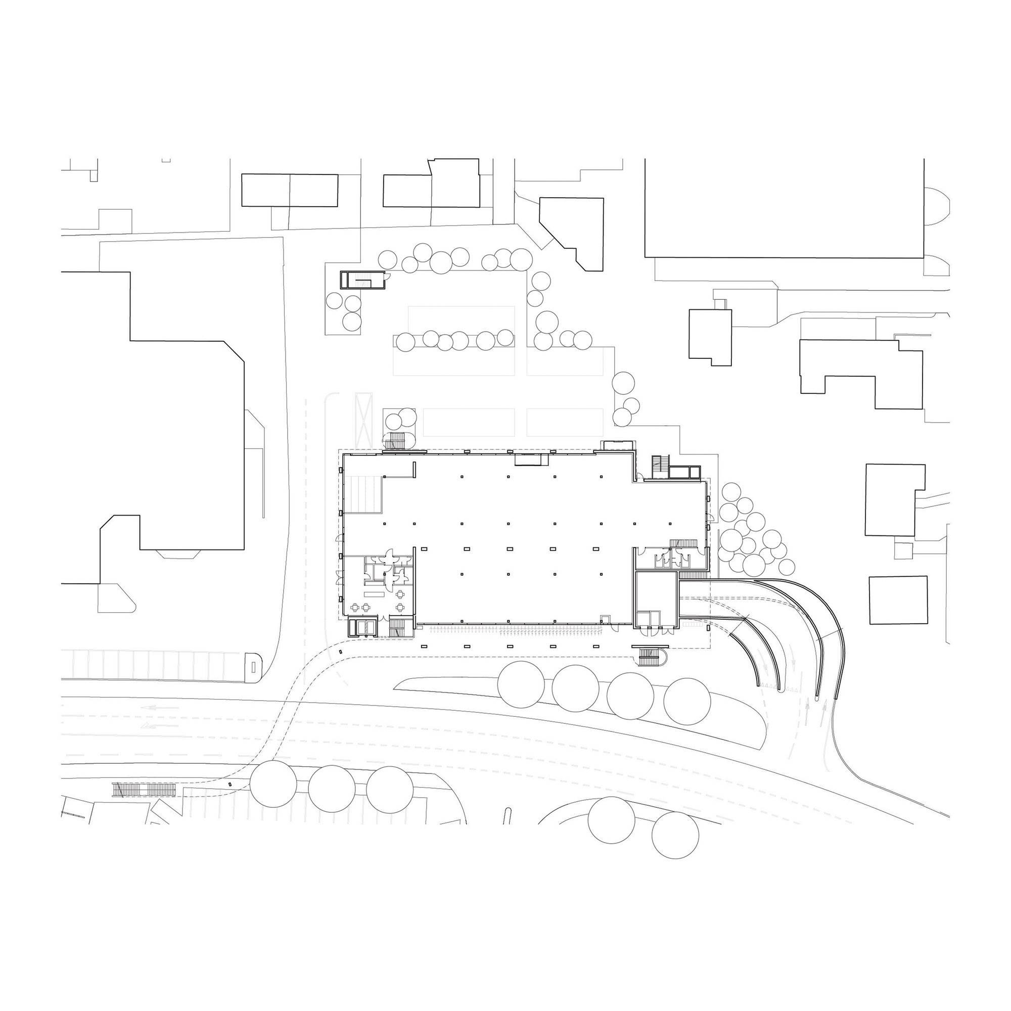 Site plan drawing showing the building footprint surrounded by street trees and adjacent structures