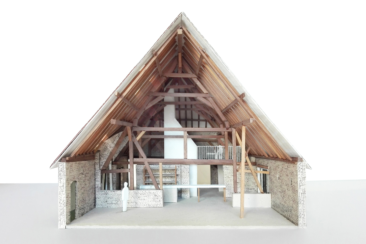 Section model showing exposed timber roof trusses and brick walls with interior mezzanine level