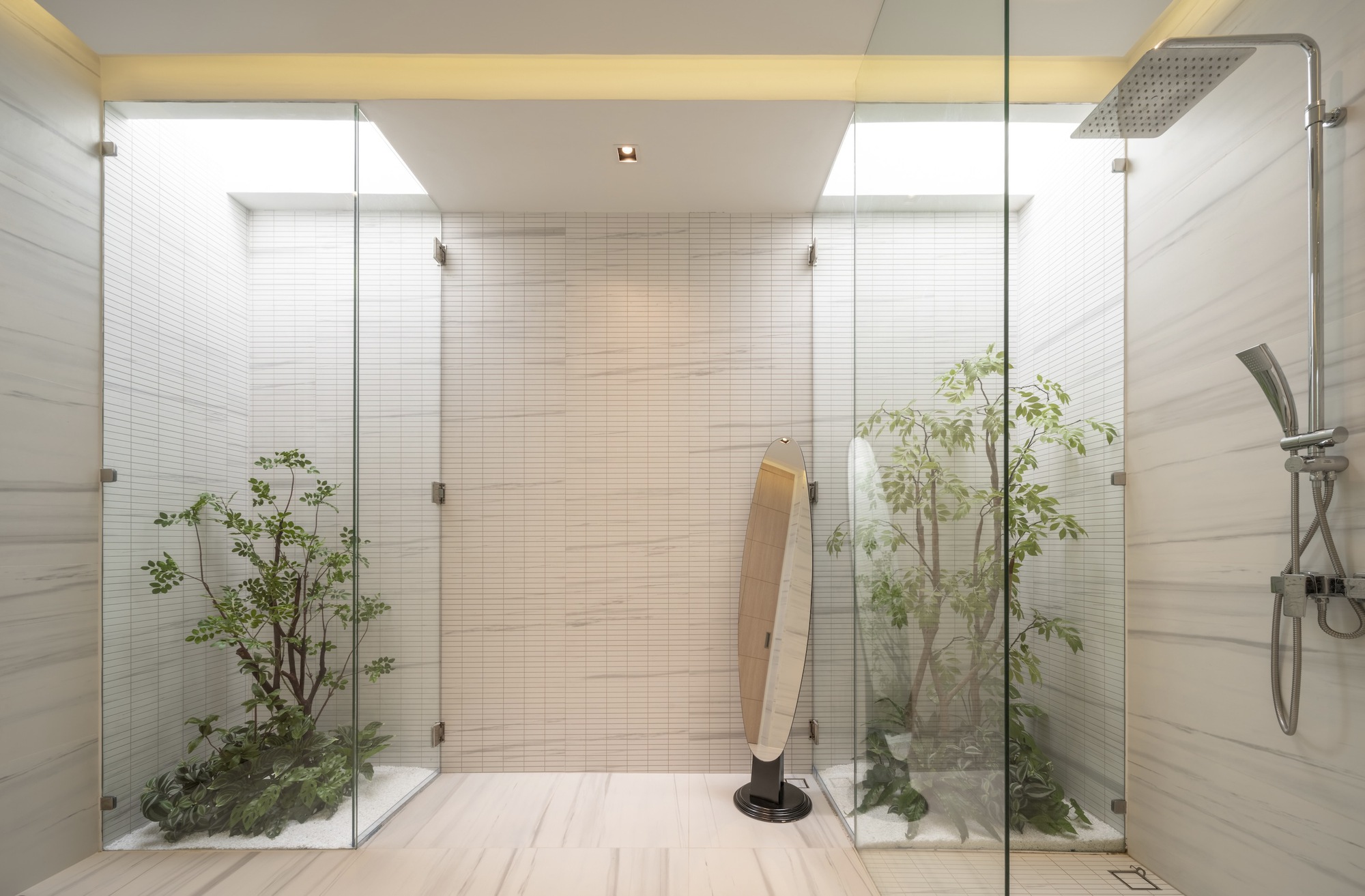 Bathroom with glass-enclosed planting beds flanking a timber bench and overhead rain shower