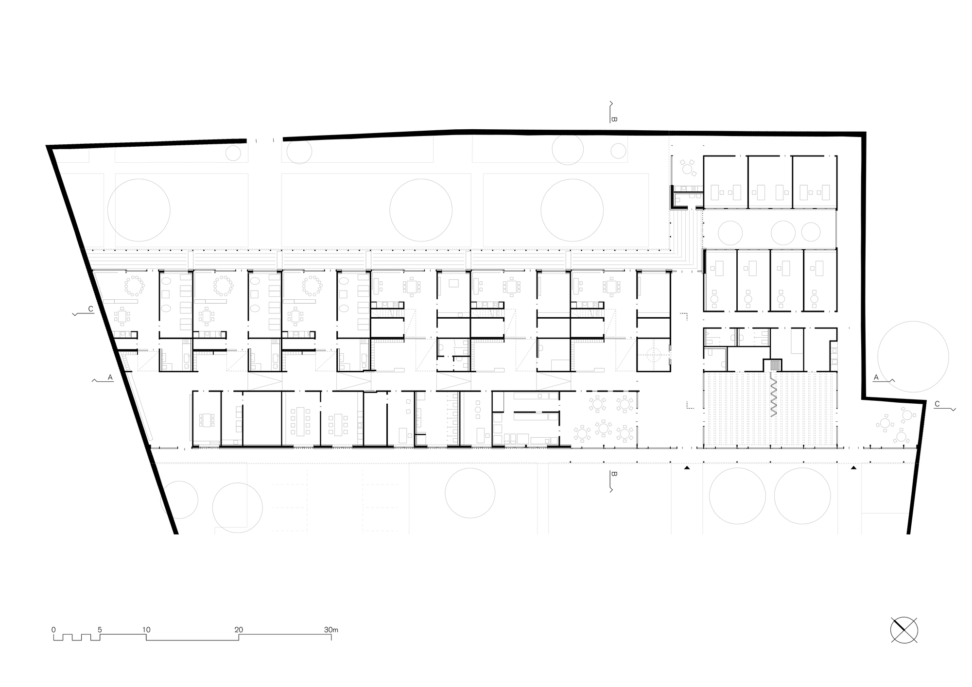 Floor plan drawing showing repeated linear classroom units flanking a corridor with circular elements