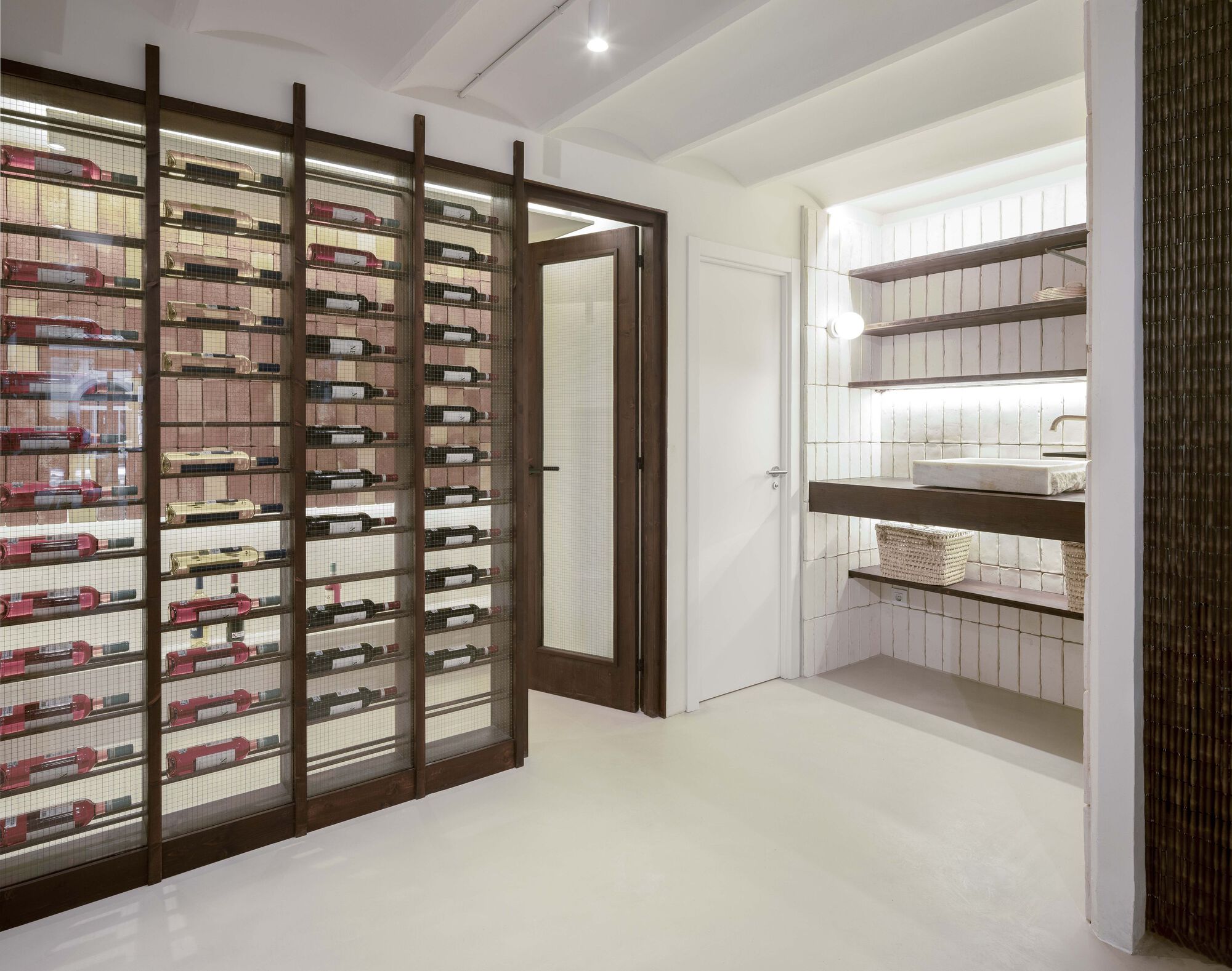 Timber and mesh wine rack framing a doorway with tiled bathroom visible beyond