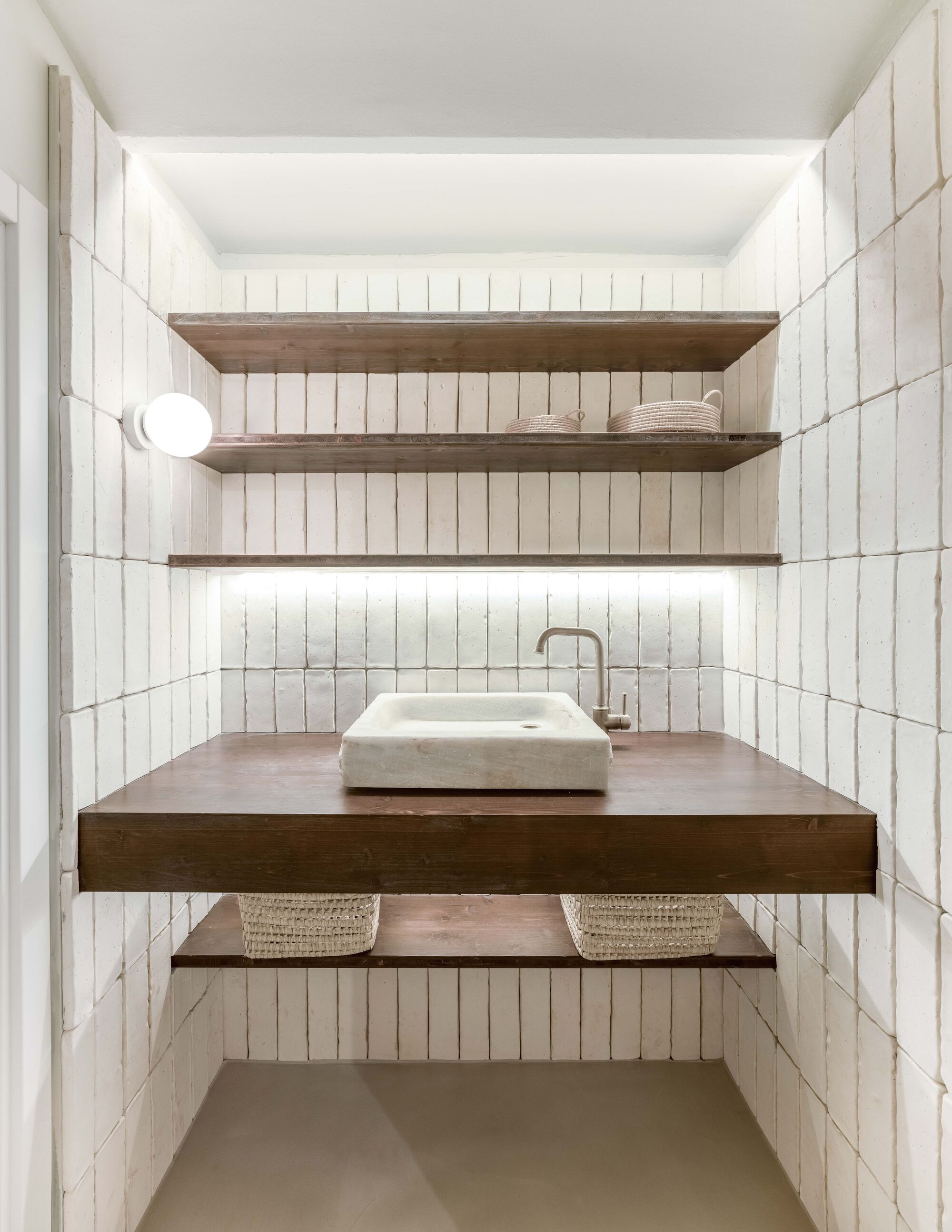 Compact washroom with white vertical tile walls and floating timber vanity with stone basin