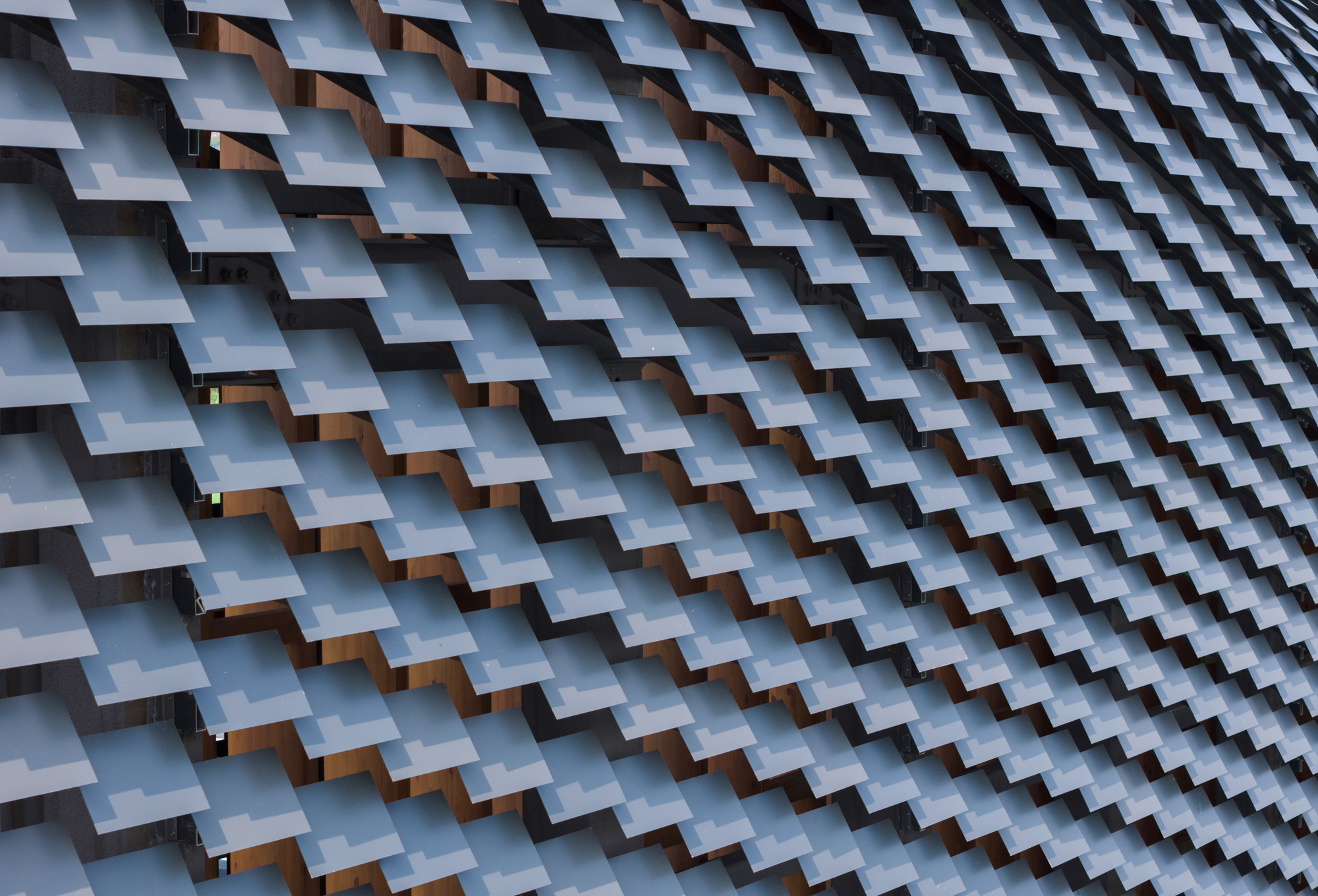 Close-up of interlocking ceramic tile roof cladding creating a repetitive diagonal pattern