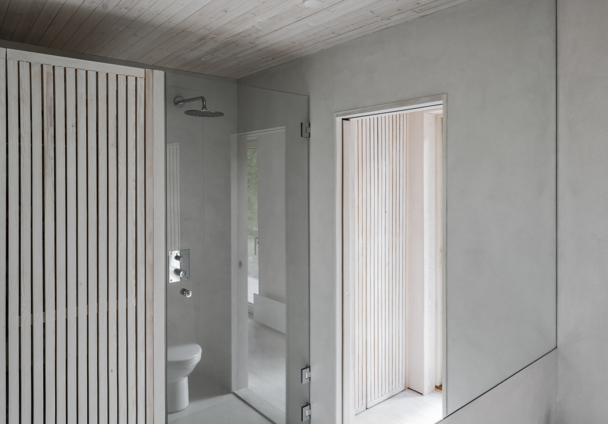Bathroom with vertical timber slat screen, glass shower enclosure, and pale wood plank ceiling