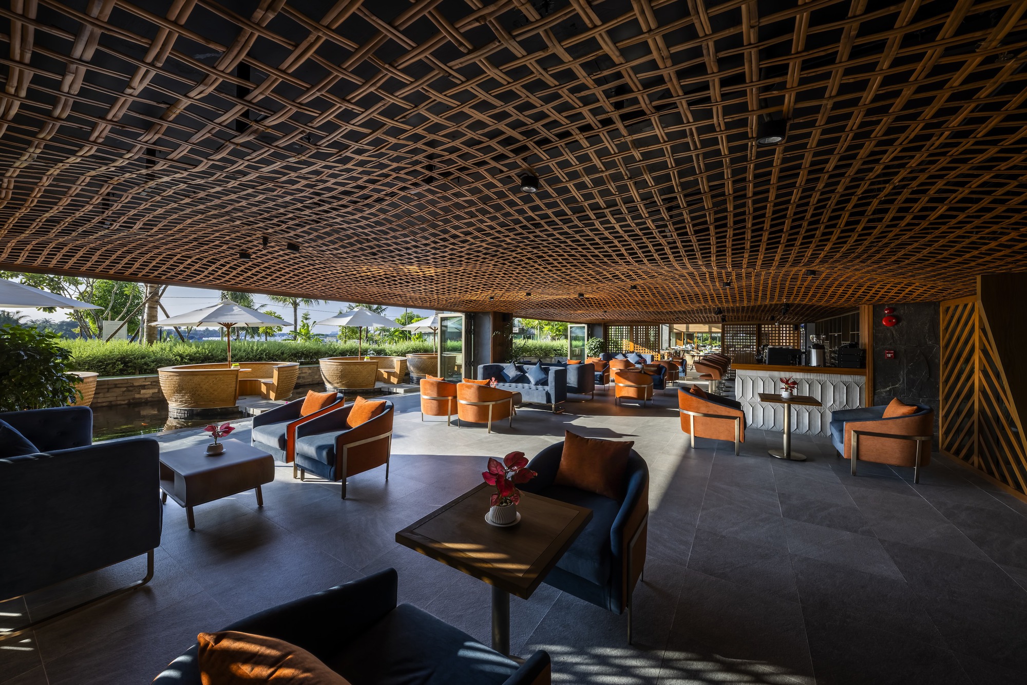 Lounge space with timber lattice ceiling and grouped seating looking onto terrace and landscaping